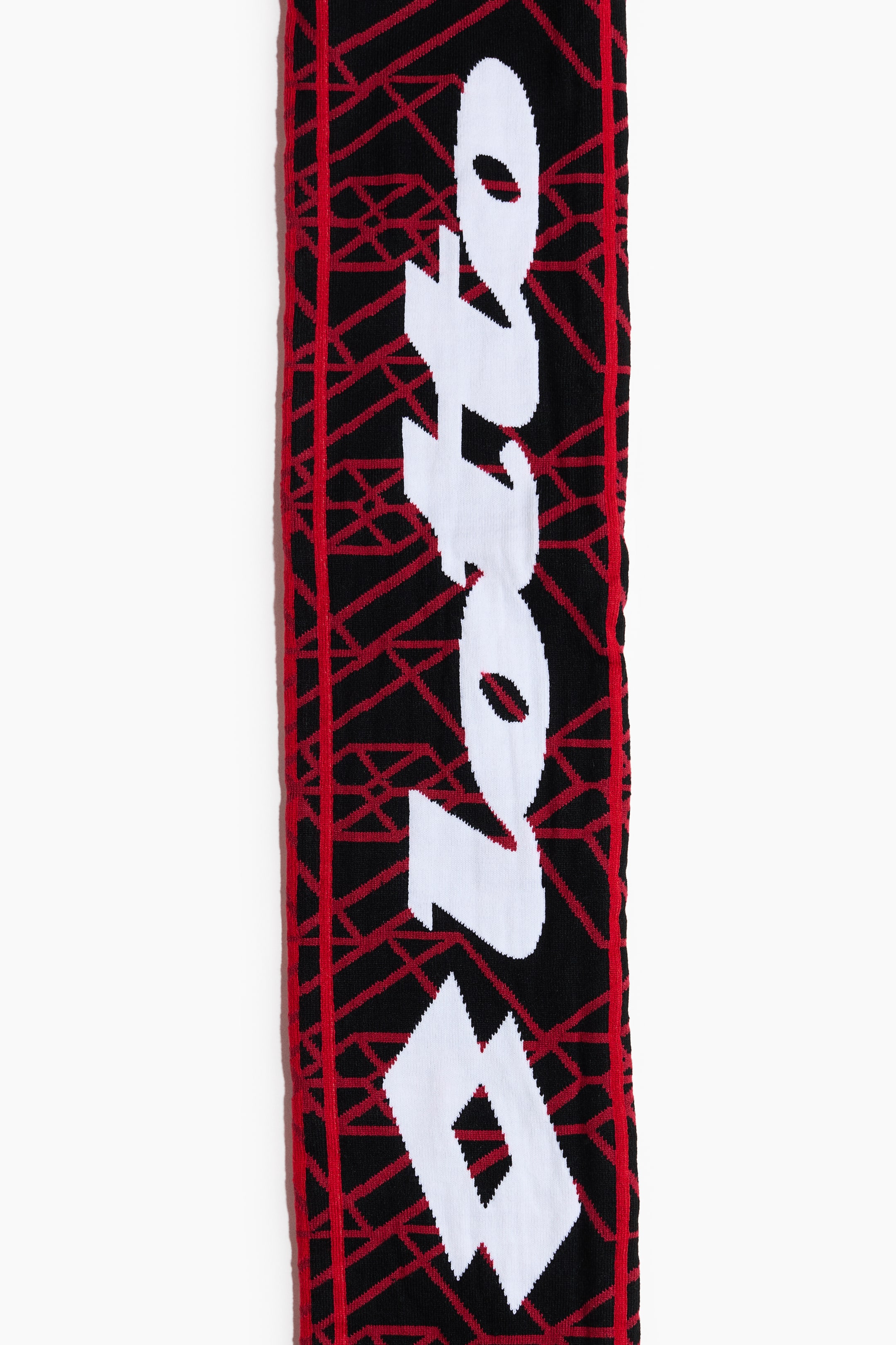 View larger image: This knitted scarf showcases a black base adorned with a red geometric pattern, while the white 'Lotto' text stands out vertically. Below the text, a white diamond logo is featured, with red stripes elegantly lining the scarf's edges.
