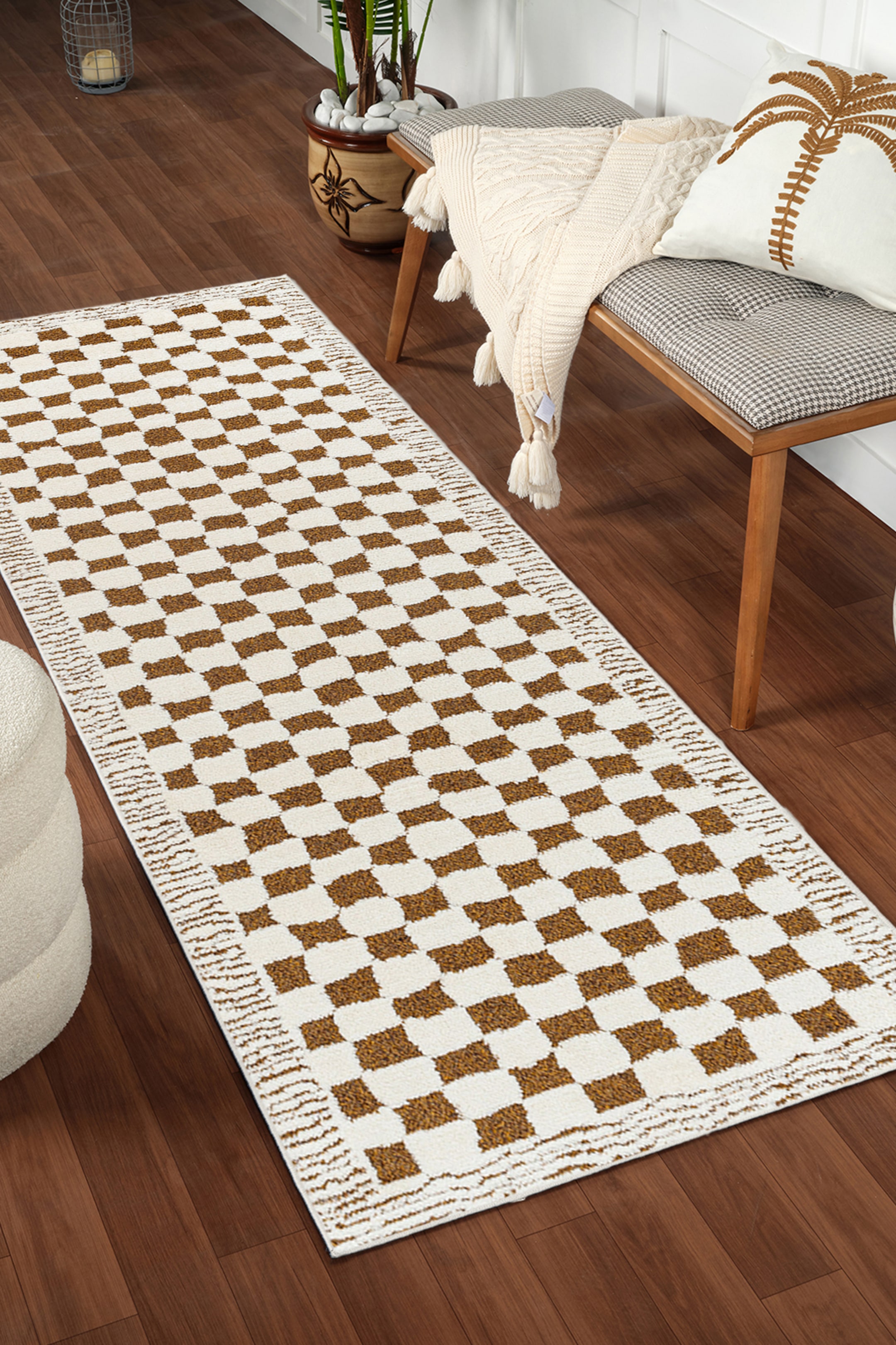 View larger image: A runner rug showcasing a chequerboard pattern of off-white and golden brown squares. Its surface features a textured pile, and its long sides are bordered with a dense, woven texture.