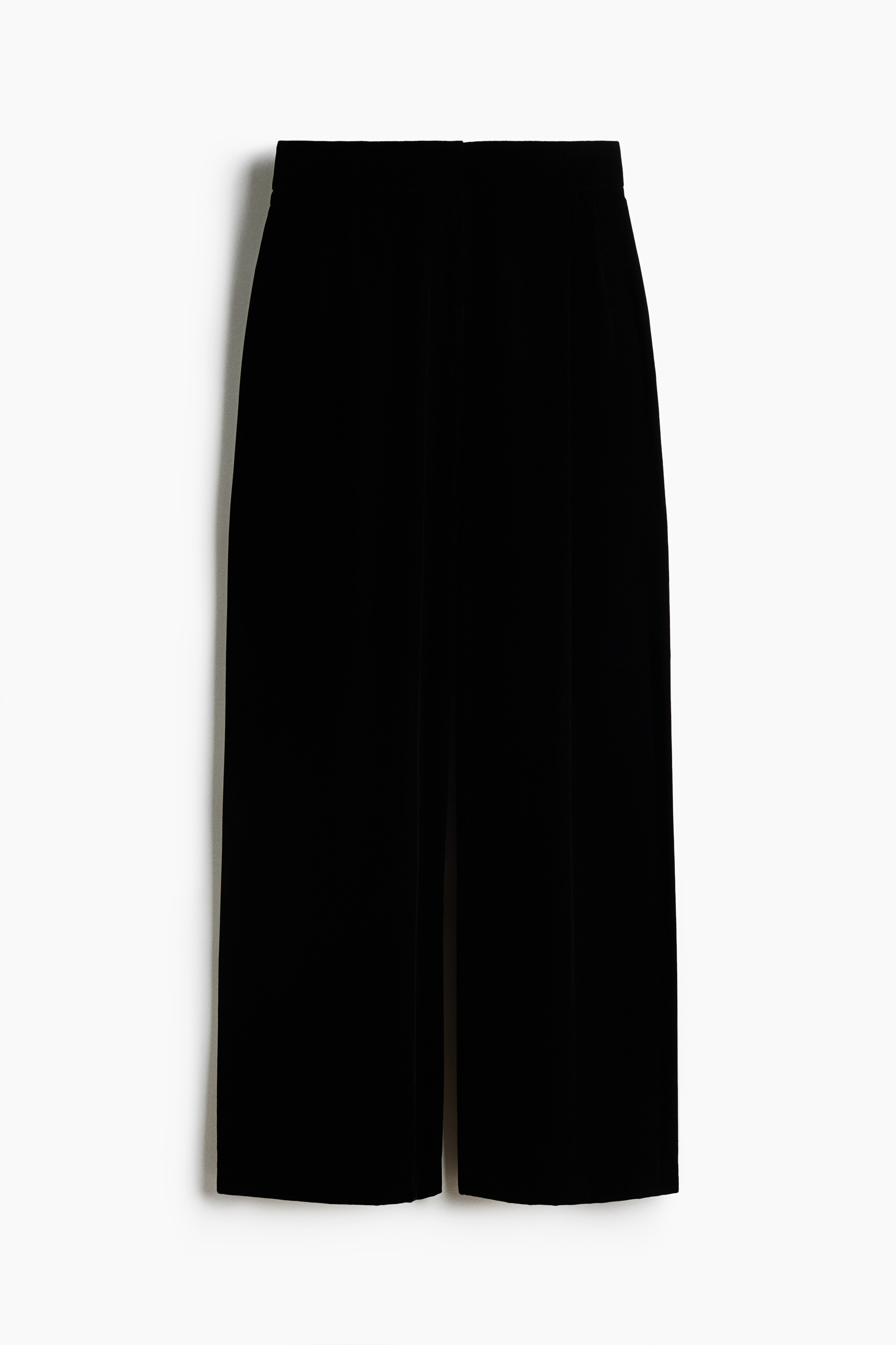 Le mannequin porte un pantalon noir Ã  jambe large, agencÃ© Ã  une veste noire Ã  manches longues assortie et Ã  un haut court noir. Le pantalon prÃ©sente une taille haute et une silhouette dÃ©contractÃ©e Ã  jambe large qui tombe jusquâau sol.