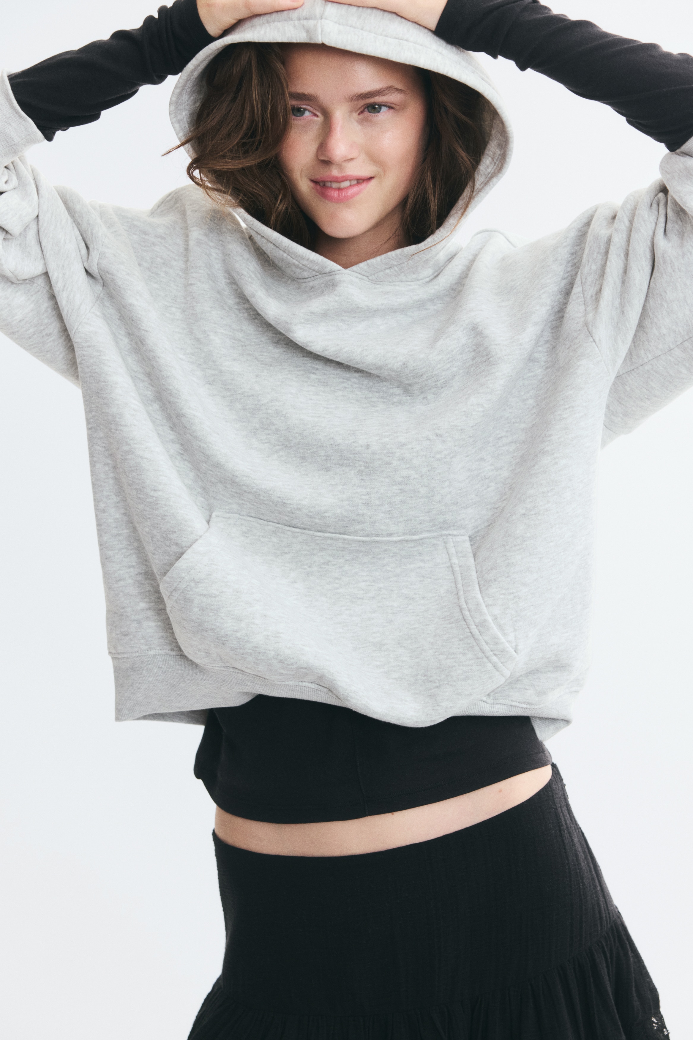 Má»t chiáº¿c Ã¡o hoodie mÃ u xÃ¡m nháº¡t melange Äang ÄÆ°á»£c chá»¥p chÃ­nh diá»n, vá»i mÅ© trÃ¹m cÃ³ lÃ³t jersey, vai trá» vÃ  tay dÃ i bo gÃ¢n á» cá» tay. Thiáº¿t káº¿ ná»i báº­t vá»i tÃºi kangaroo phÃ­a trÆ°á»c vÃ  gáº¥u Ã¡o bo gÃ¢n.