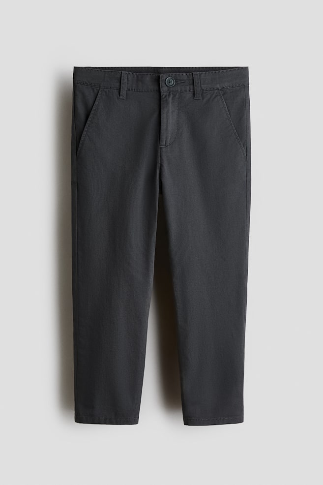 Dark gray chinos made of soft cotton twill are presenting face-on, showcasing a regular fit with tapered legs. They are featuring a button closure above a zip fly and diagonal side pockets. - 1