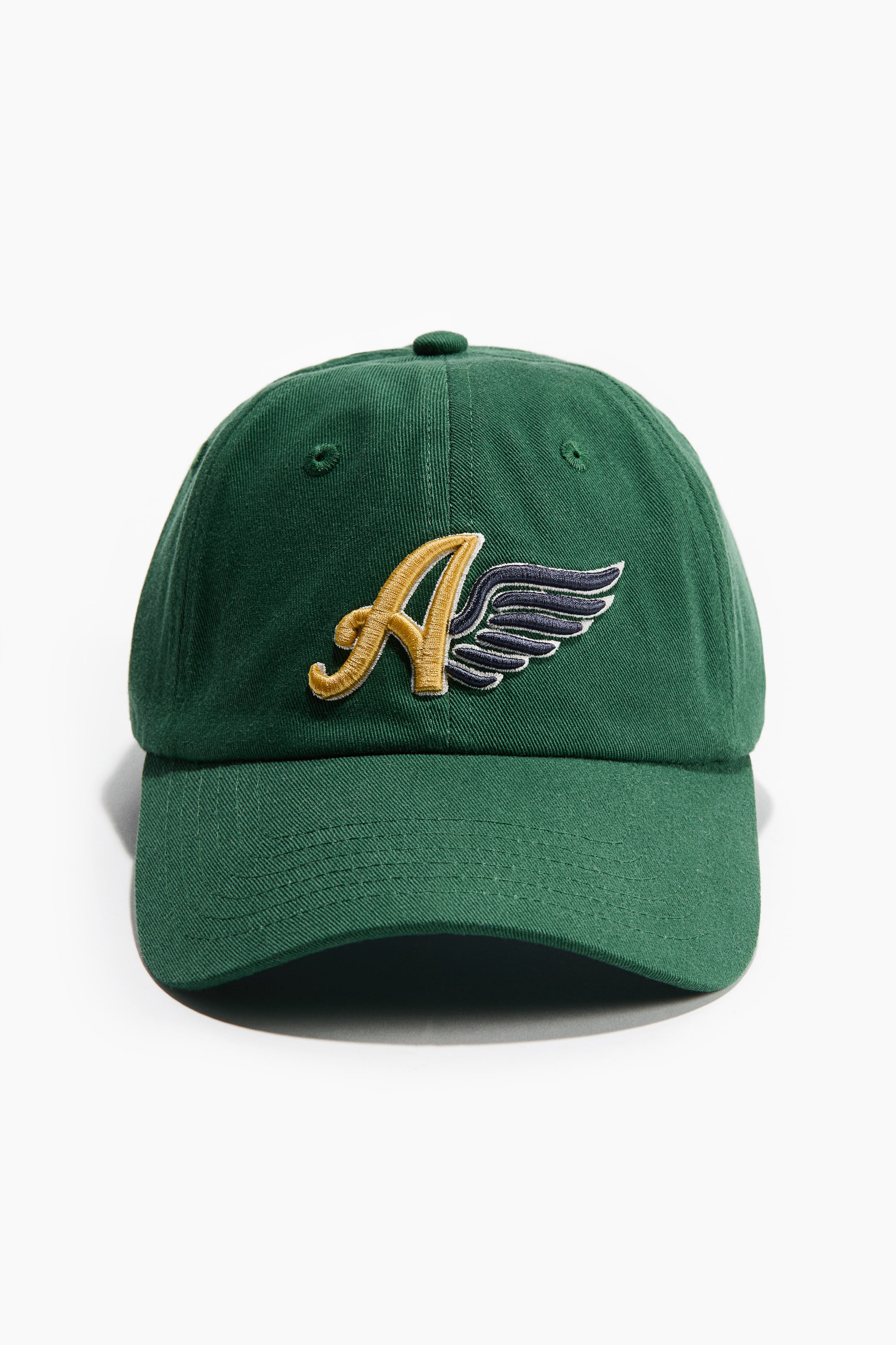 View larger image: A dark green baseball cap is facing front, featuring a golden yellow embroidered letter "A" with dark blue embroidered wings, outlined in white, on its front panel.