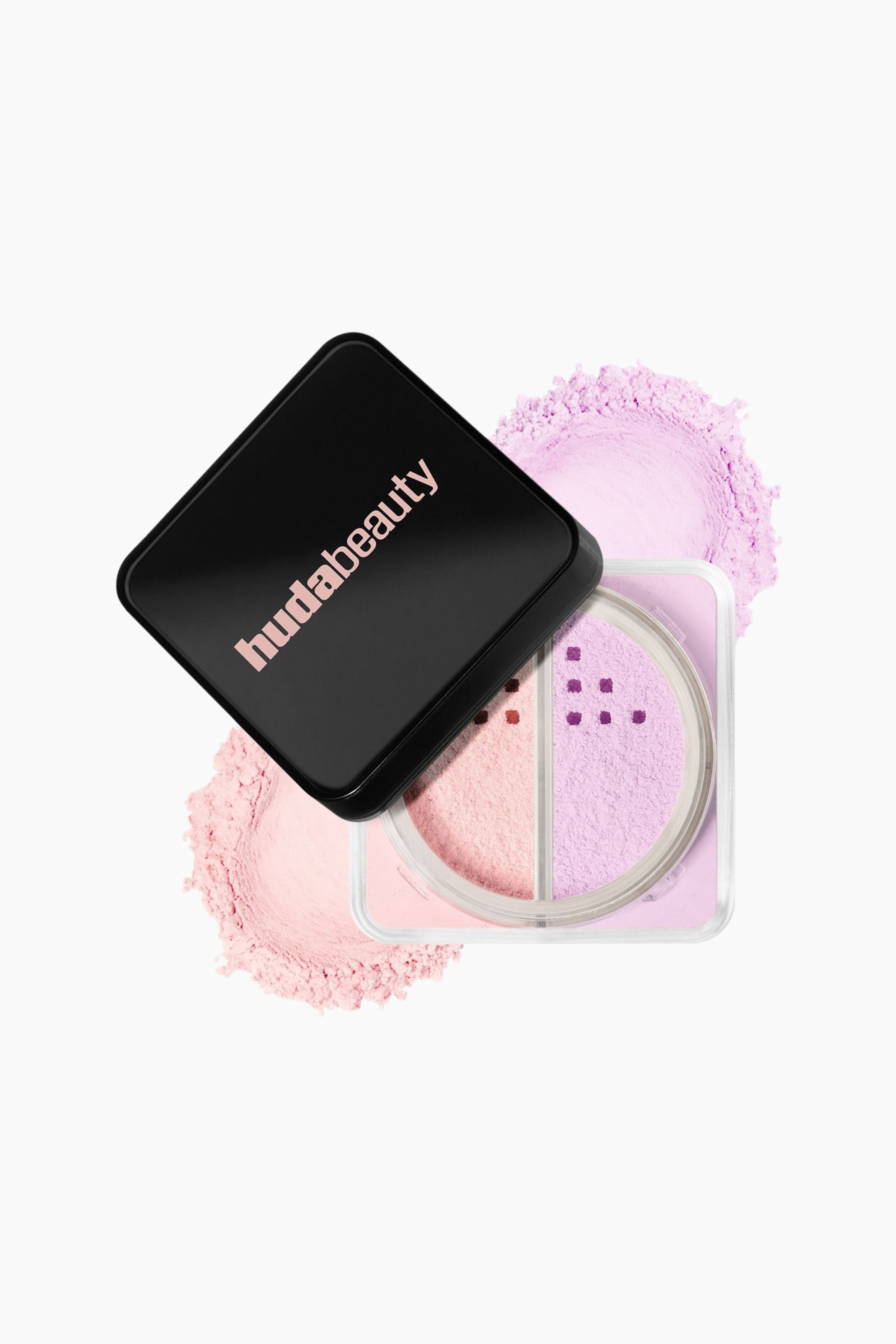Visa större bild: En lös puderbehållare från Huda Beauty visar två tydliga fack med ljusrosa och ljuslila puder, åtskilda längs mitten. Ett svart fyrkantigt lock med varumärkesnamnet "hudabeauty" ligger i vinkel ovanpå den прозрачna behållaren, som är placerad ovanpå färgprover av de matchande rosa och lila pudren.