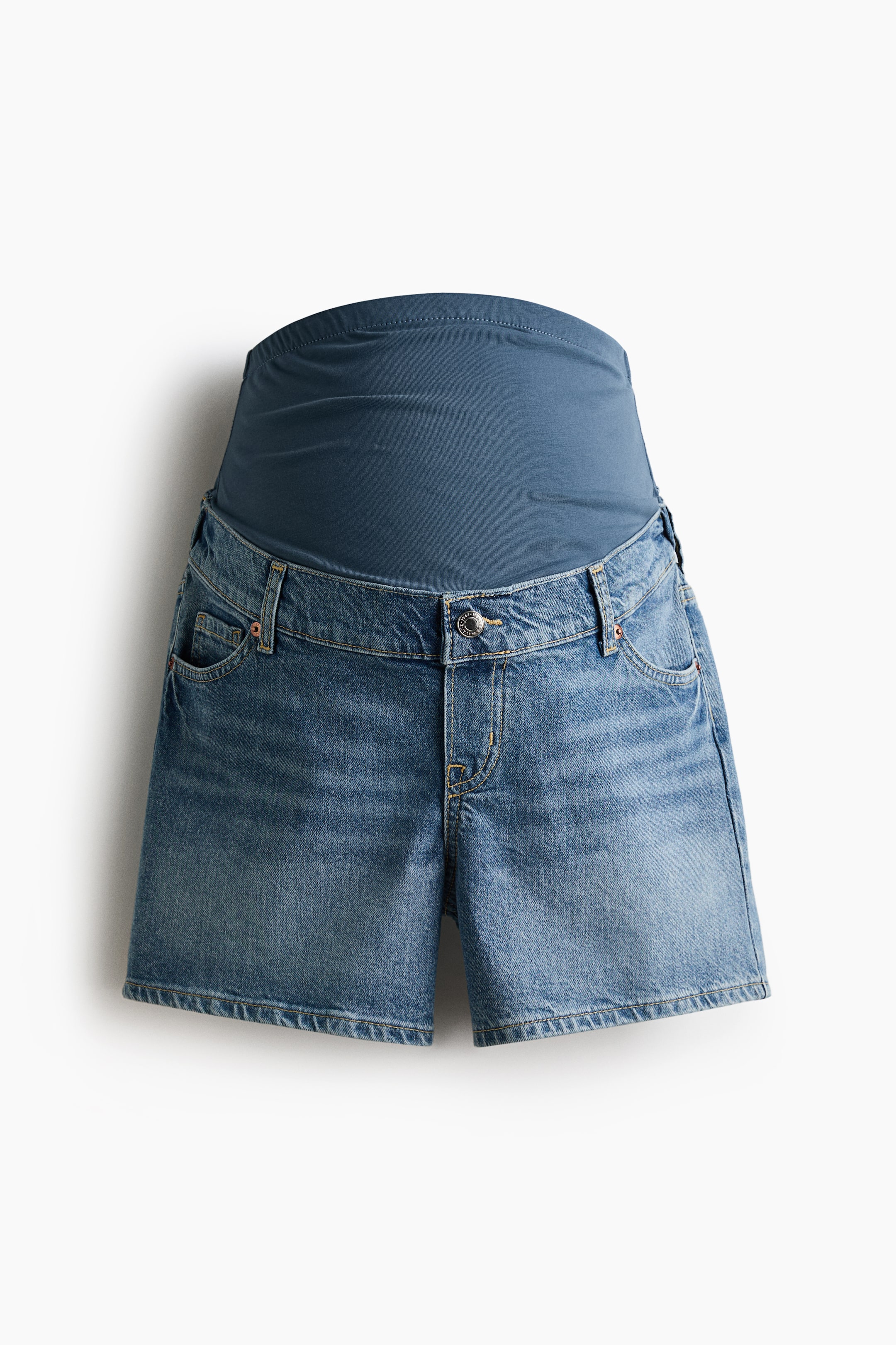 Se større billede: Maternity denimshorts vender fronten mod kameraet, med en lys blå vask og et 5-lomme design. Et bredt, mørkeblåt jerseypanel strækker sig fra taljen på shortsene, hvilket sikrer en behagelig pasform over maven.