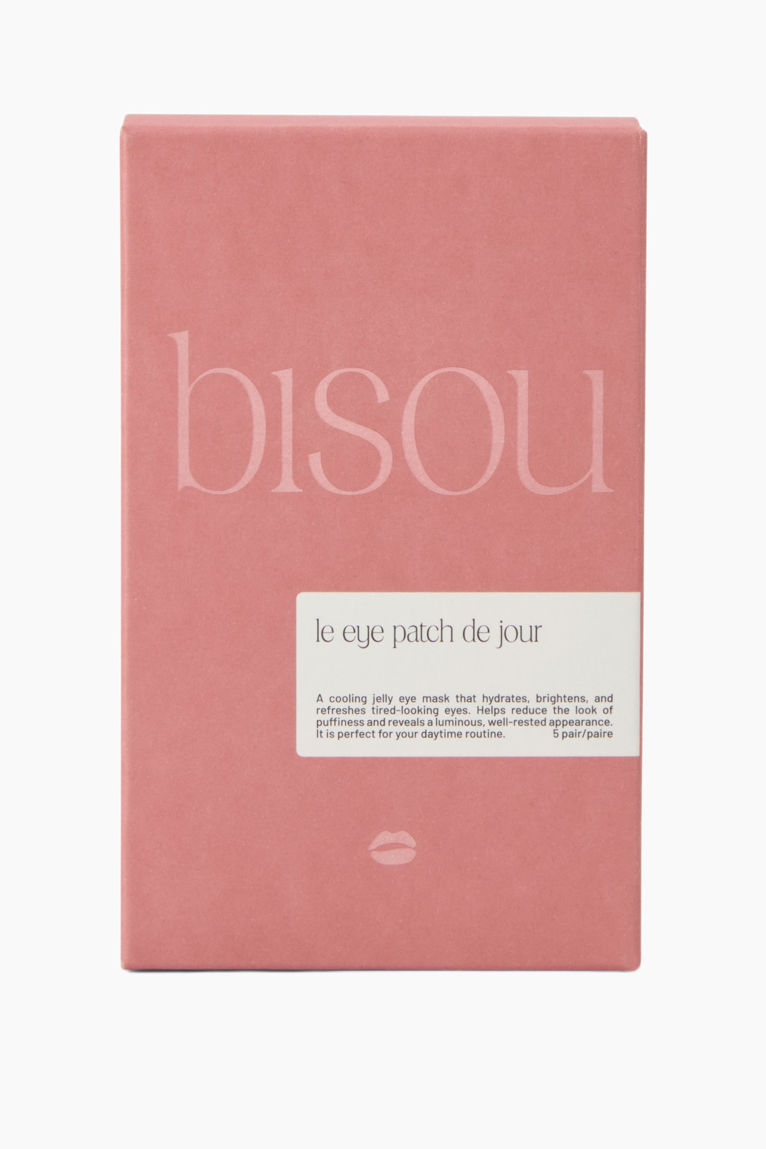 En rektangulÃ¤r dammrosa ask fÃ¶r "le eye patch de jour" stÃ¥r upprÃ¤tt och visar sin framsida. Asken har en stor, blekt rosa "bisou"-logotyp Ã¶ver mitten, en vit rektangulÃ¤r etikett med produktinformation nere till hÃ¶ger och en liten vit lÃ¤pplikon nÃ¤ra botten.