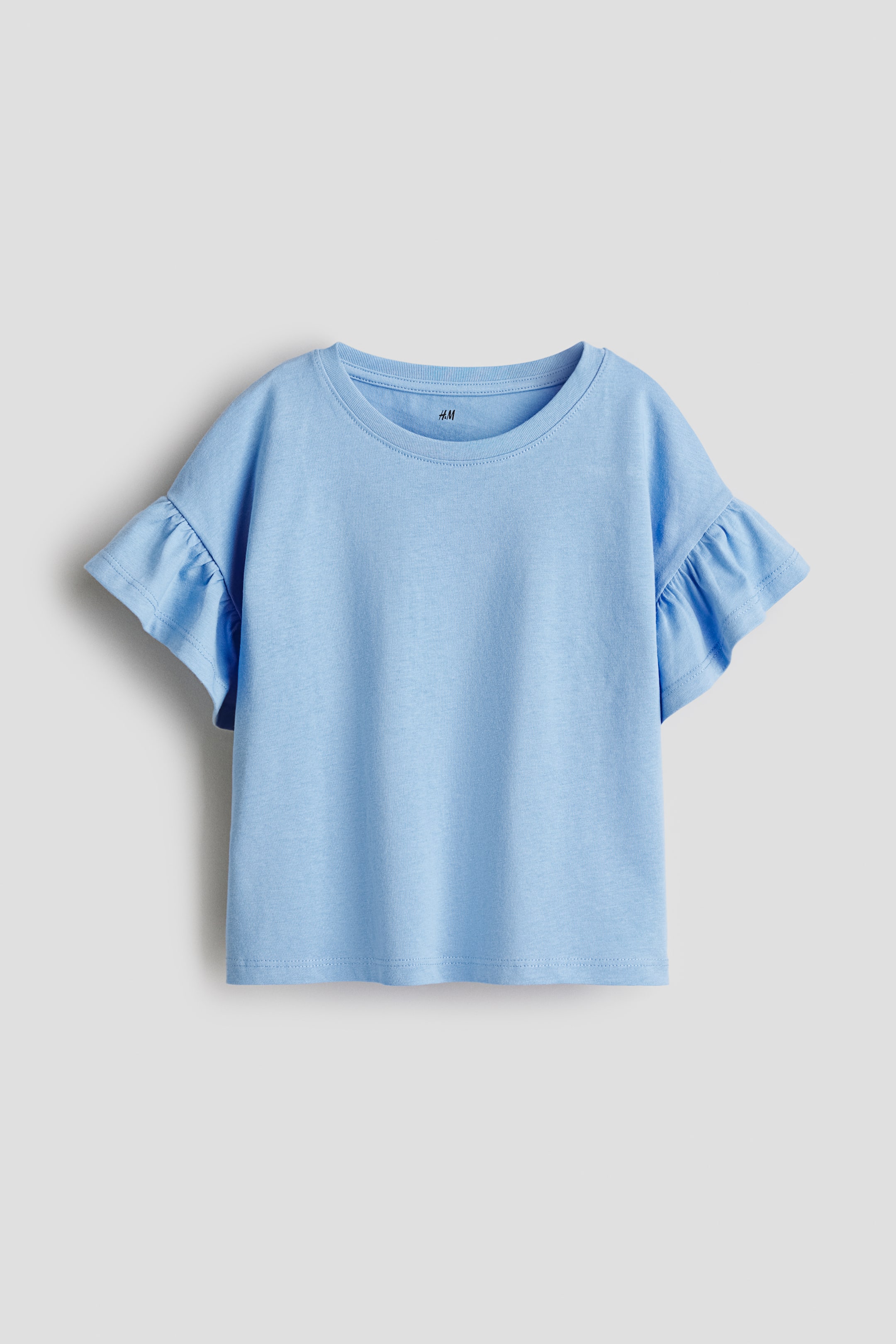 View larger image: A light blue t-shirt is presenting its front, featuring a round neckline and short sleeves with gathered ruffles.