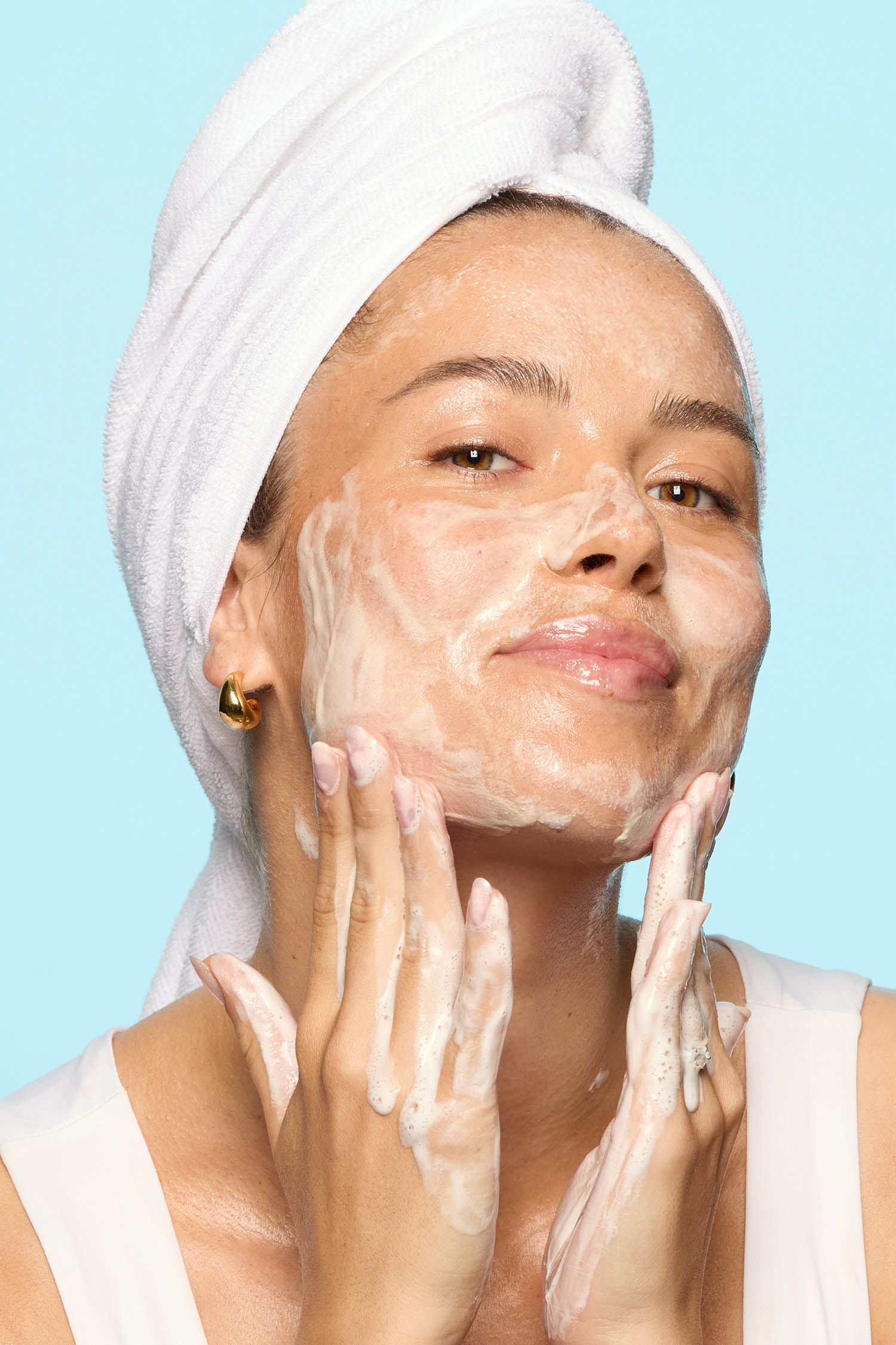 Vaaleanpunainen voidepuhdistusaineen tuubi seisoo pystyasennossa ja on eteenpäin suunnattu, ja siinä on metallikirjaimin kirjoitettu "HICKAP" yläosassa ja "dream barrier cream cleanser" sen alapuolella. Yhteensopiva käännettävä korkki on näkyvissä tuubin alaosassa.
