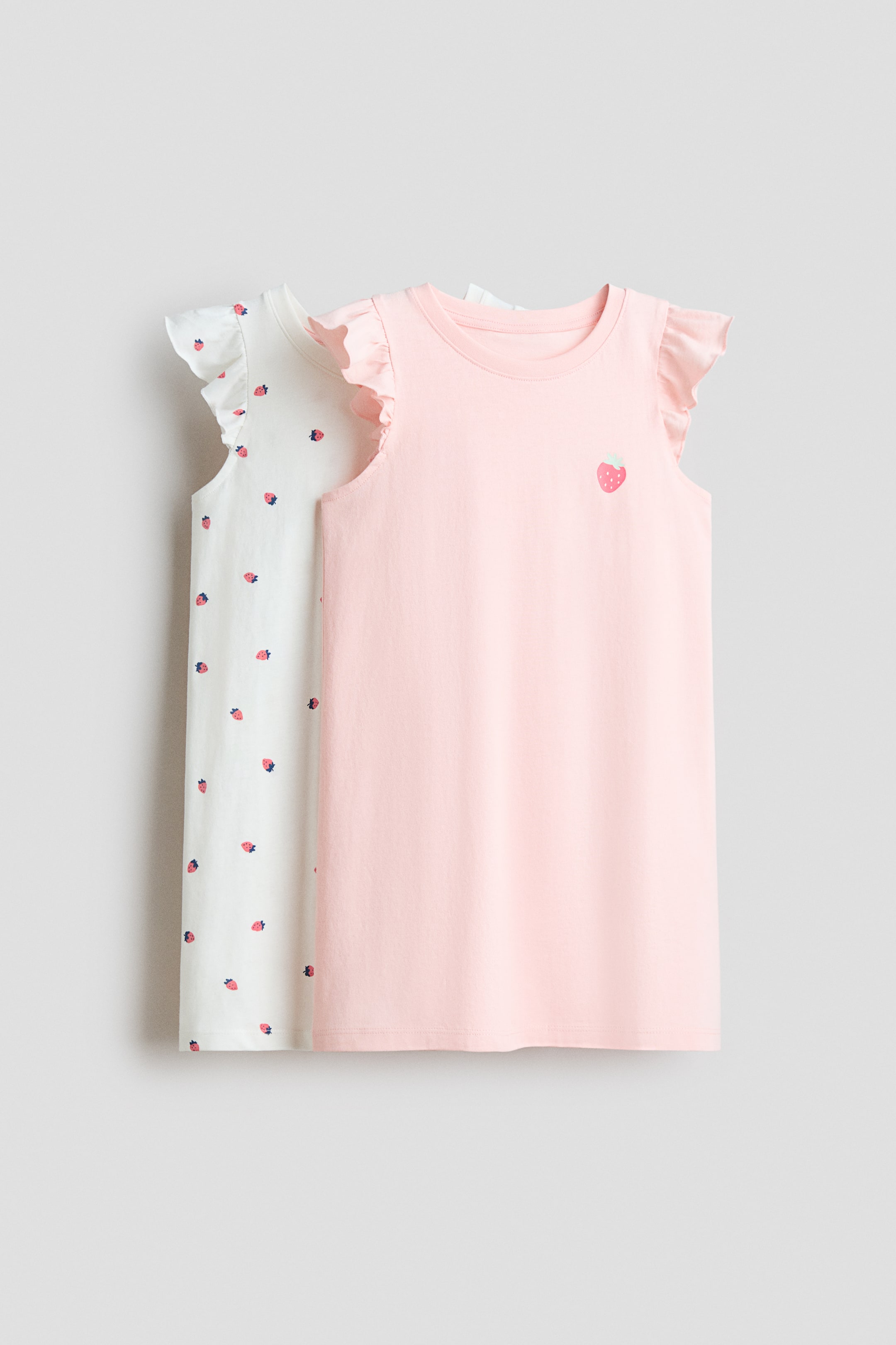 查看大圖: 柔軟棉質針織睡裙以正面 FRONT 呈現，展現圓領設計與荷葉袖。一件為淡粉紅色，飾有小草莓 appliqué；另一件為白色，整件為草莓印花。