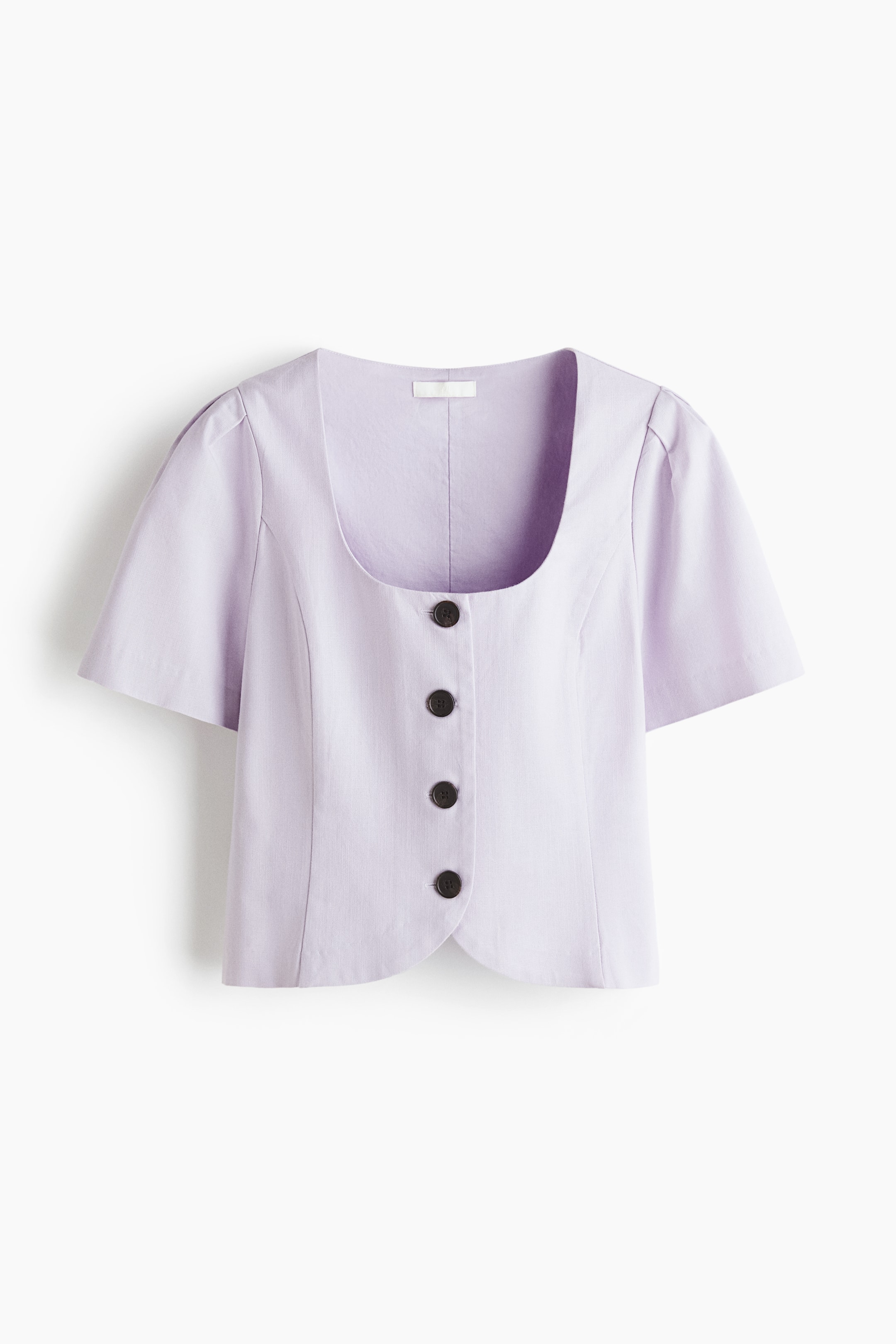 Grotere afbeelding bekijken: Een korte, aansluitende blouse in lichtpaars toont zijn vooraanzicht, met een ronde halslijn, vier donkere knopen aan de voorkant, korte pofmouwen en een gebogen zoom.