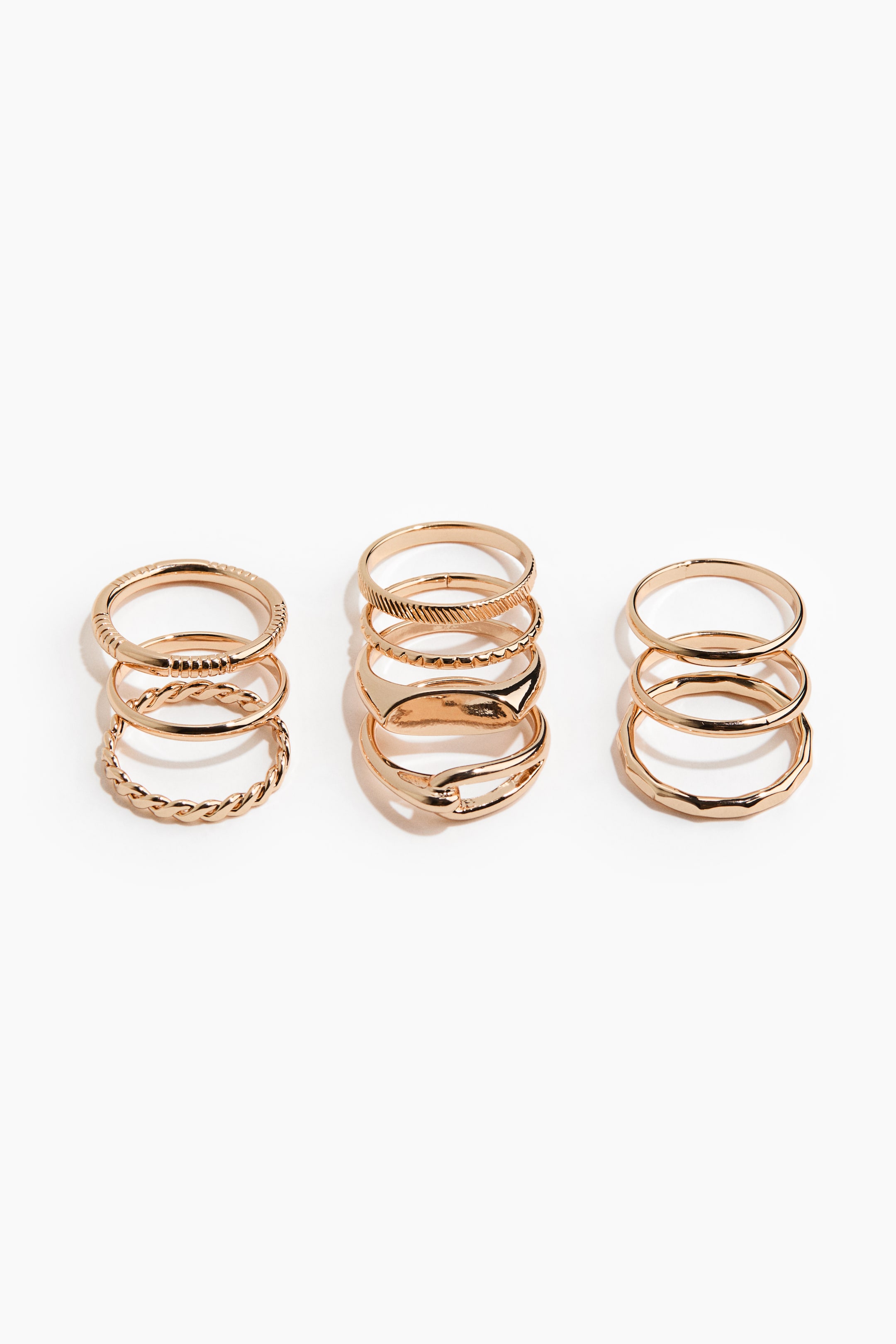 Ver imagen más grande: El producto presenta tres juegos de anillos en tono dorado, colocados en posición vertical y mostrando una variedad de diseños. Estos diseños incluyen bandas lisas, retorcidas, texturizadas, de sello, estilo eslabón y facetadas.