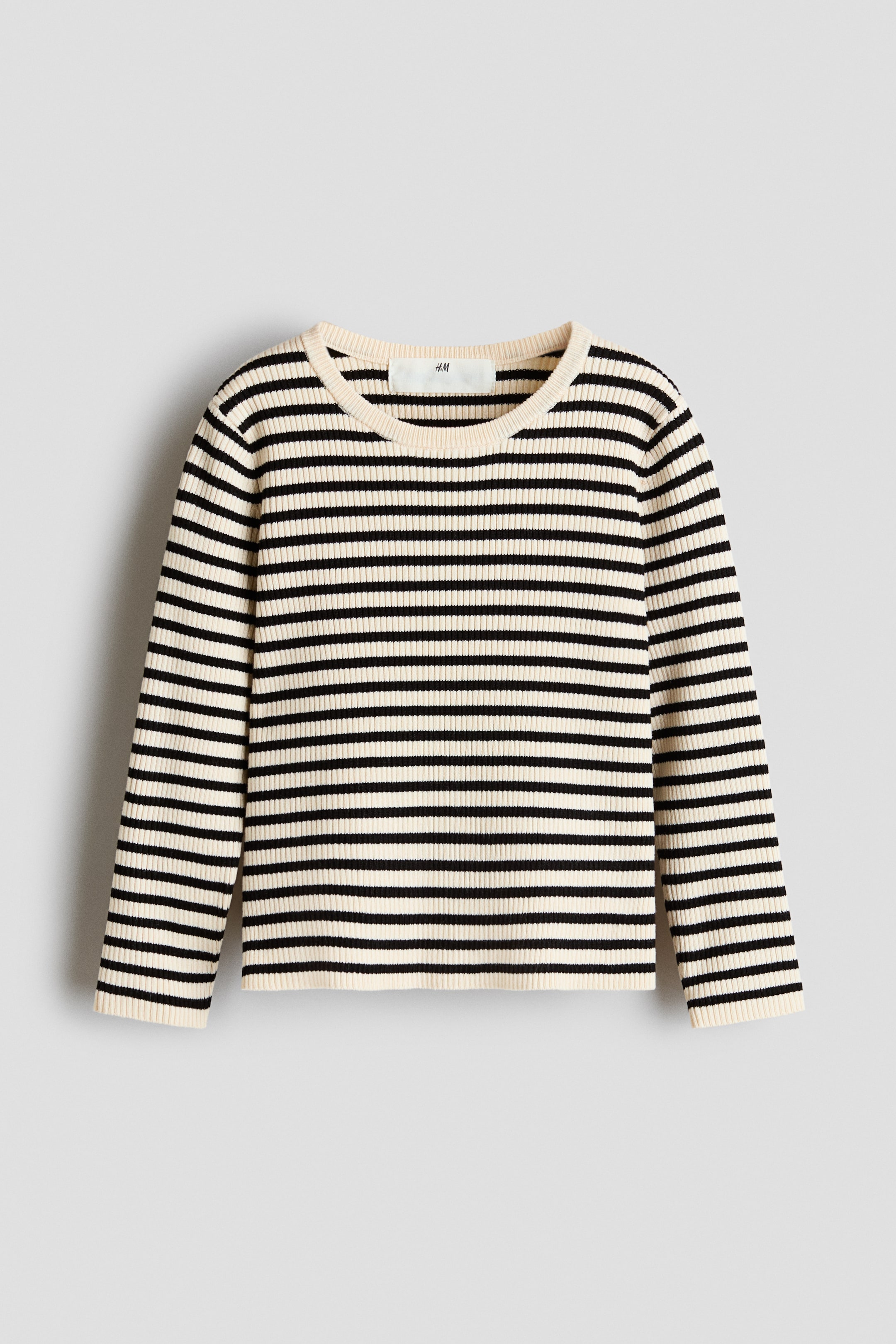 View larger image: A ribbed knit jumper is lying flat and facing forward. It features black and cream horizontal stripes, and has a crew neck and long sleeves.