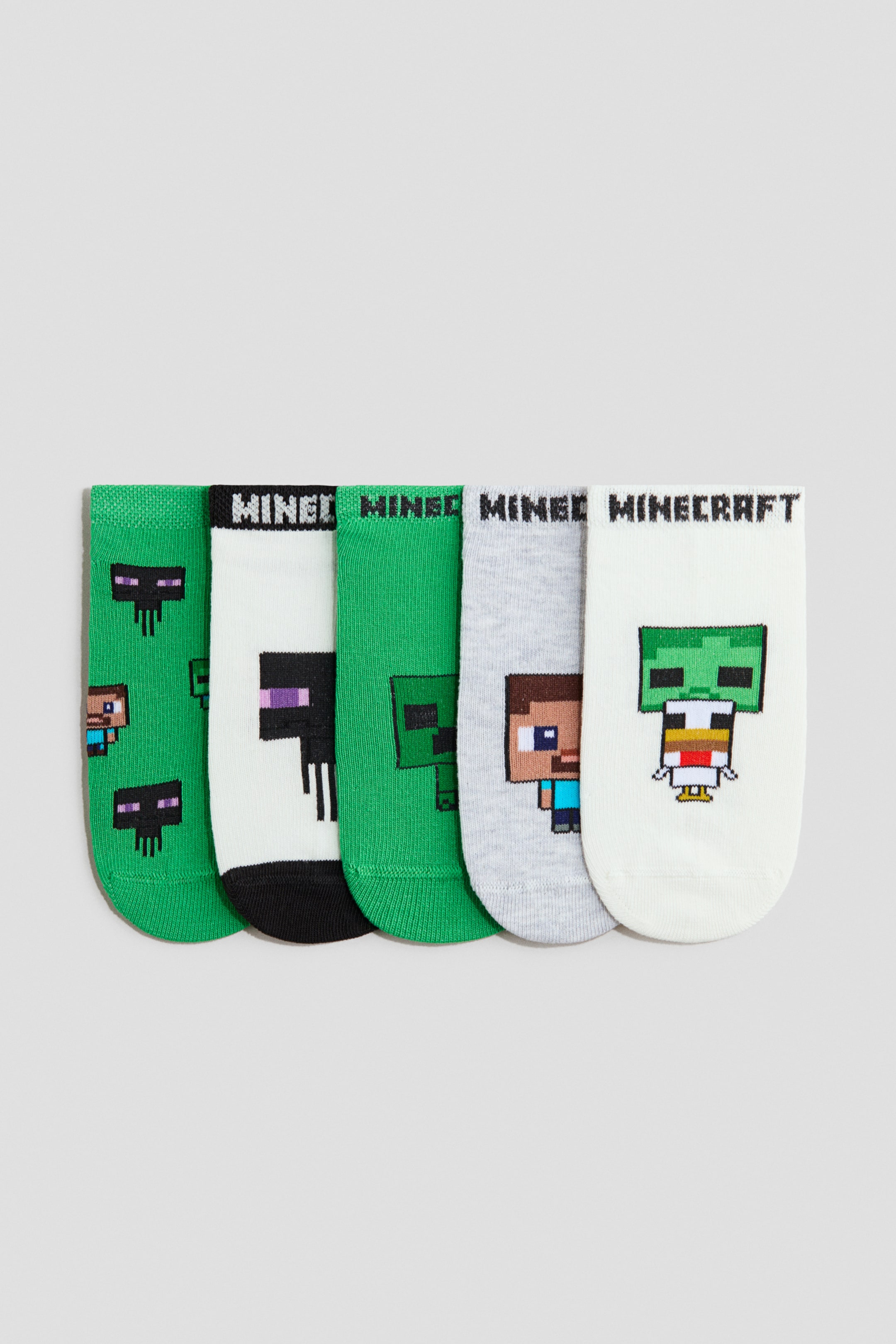 Voir une image plus grande: Chaussettes de sport en maille jacquard dans un mélange doux de coton avec élastique autour du haut, affichant une vue de face de cinq chaussettes individuelles. Chaque chaussette présente un personnage ou un logo unique de Minecraft en pixels, certaines affichant également le texte "MINED" ou "MINECRAFT" au niveau de la bande élastique.