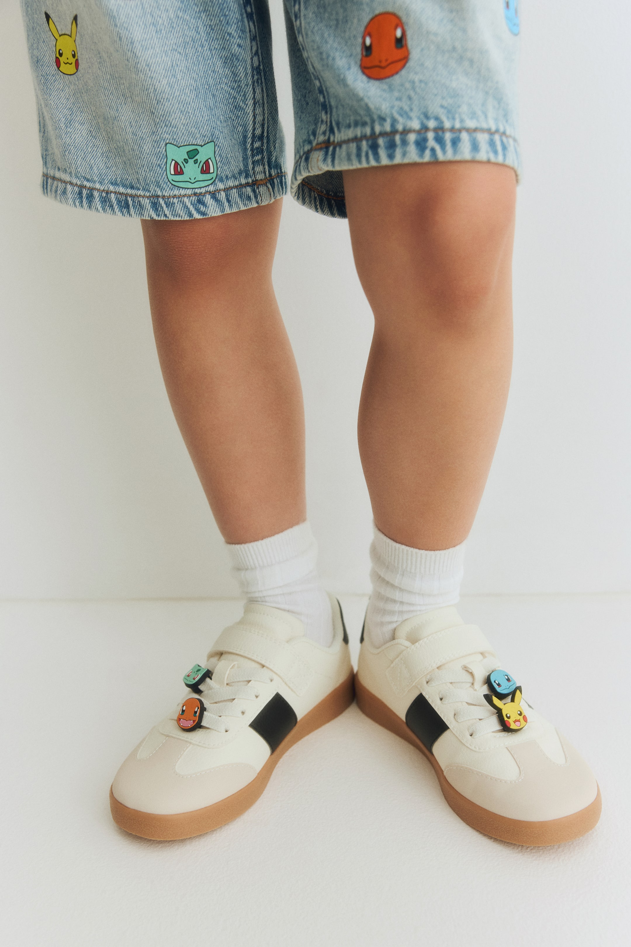 View larger image: Light blue denim shorts are being worn, featuring multiple embroidered Pokémon character patches on the front.