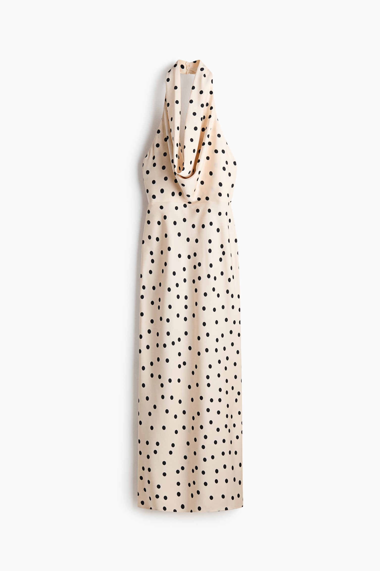 Un abito beige chiaro con collo all'americana e pois neri è appeso verticalmente, caratterizzato da uno scollo a cascata drappeggiato e una silhouette dritta e lunga fino al pavimento. - 1