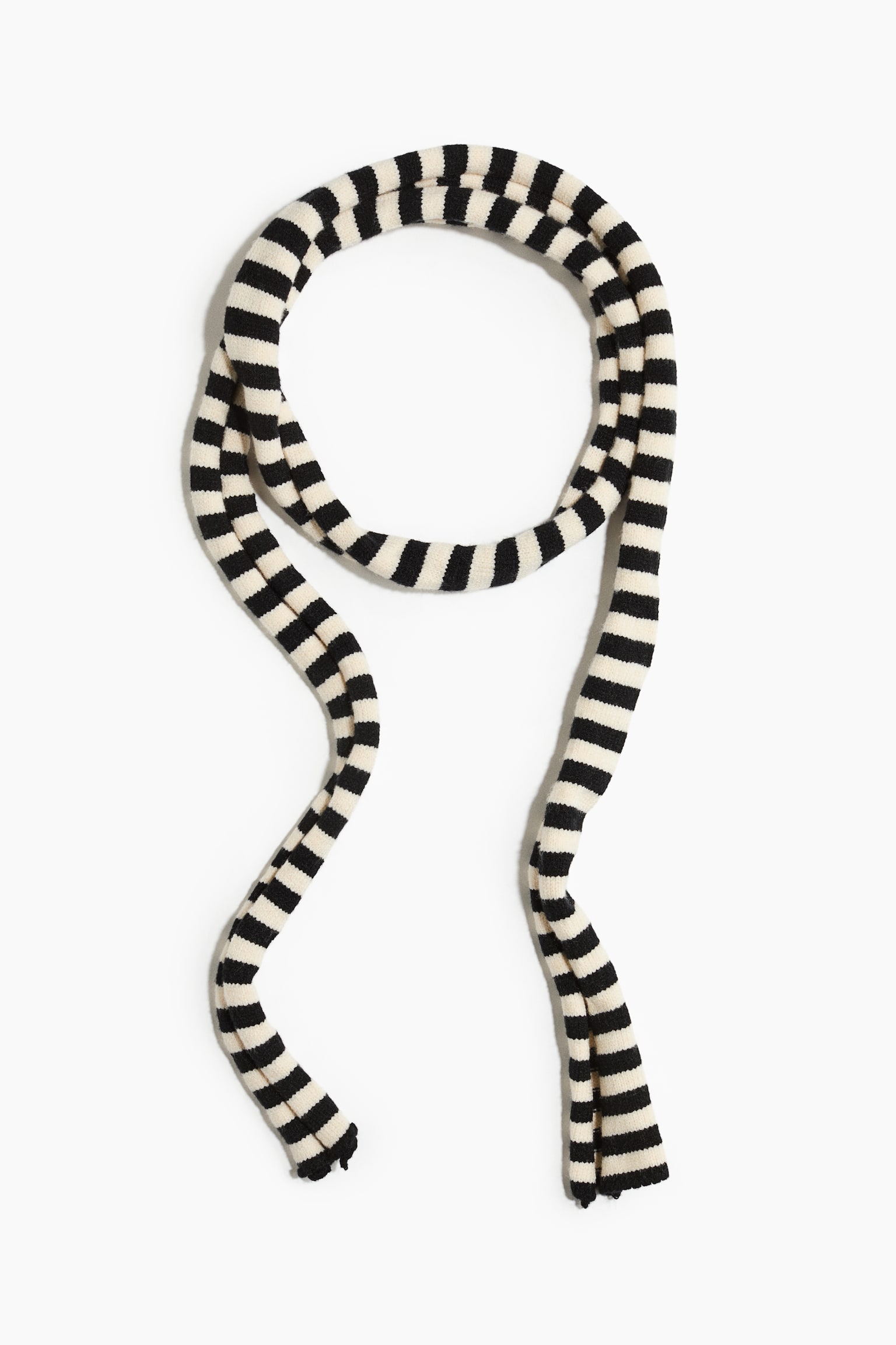 A long, narrow scarf in a viscose-blend knit is showing a pattern of alternating black and off-white horizontal stripes. The scarf is resting in a loose loop at the top with two long ends draping downward to showcase its slim, flexible structure.
