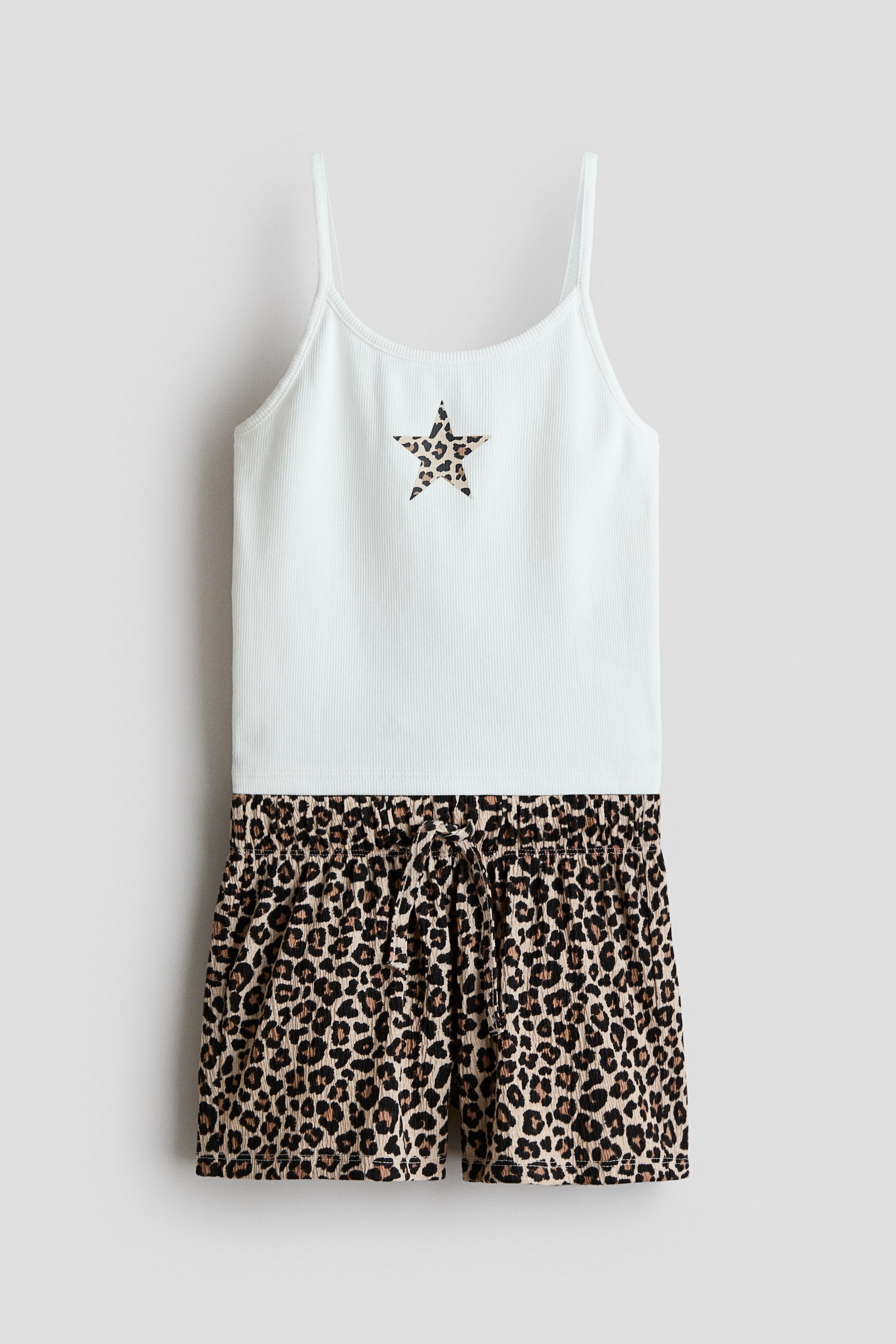 Visa större bild: Ett 2-delat set med topp och shorts presenteras fram. Den ljusblå ribbade camitoppen har tunna axelband och en leopardmönstrad stjärnapplikation på bröstet, medan de matchande ribbade shortsen visar upp ett leopardmönster, en elastisk midja och ett knutet dragsnöre.