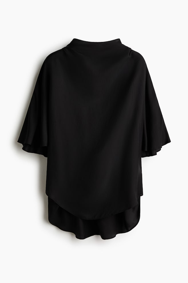 Das schwarze Oberteil zeigt seine Rückseite mit einem hohen Stehkragen und breiten, kurzen Flatterärmeln. Der Saum präsentiert ein geschichtetes, geschwungenes High-Low-Design. - 1