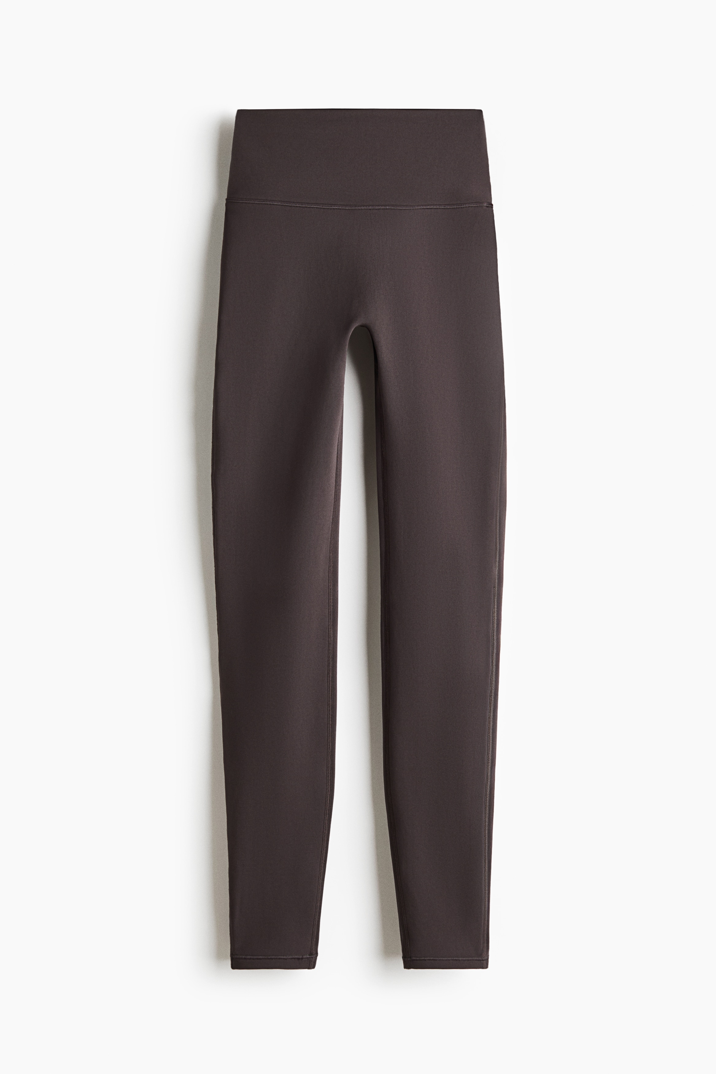 A dark plum fleece half-zip pullover is being worn by the model, paired with matching leggings. This cold-weather ensemble is styled with black winter boots and black gloves.