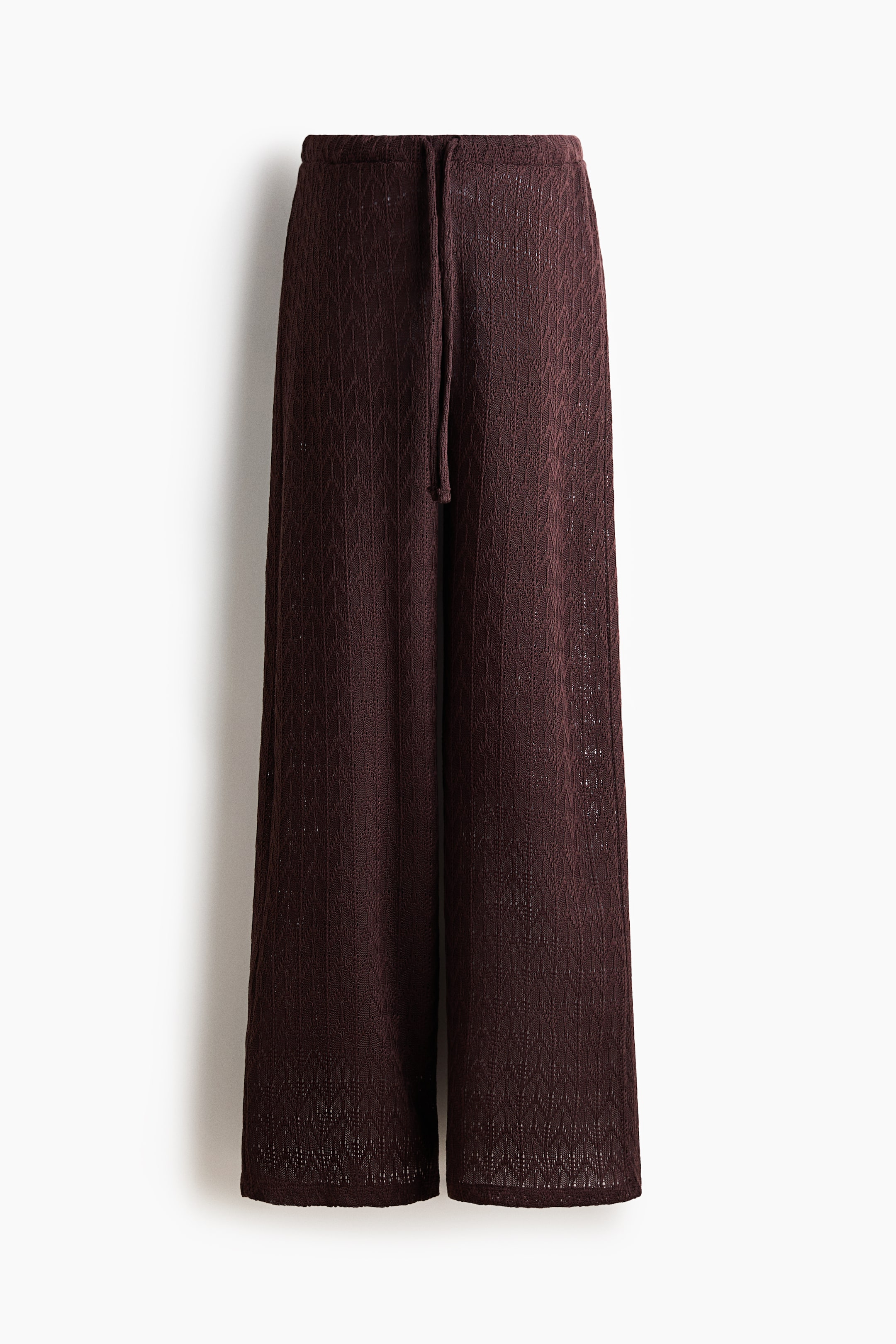 View larger image: Dark brown knit wide-leg pants featuring an all-over geometric open-knit pattern and a visible drawstring at the elasticized waistband.