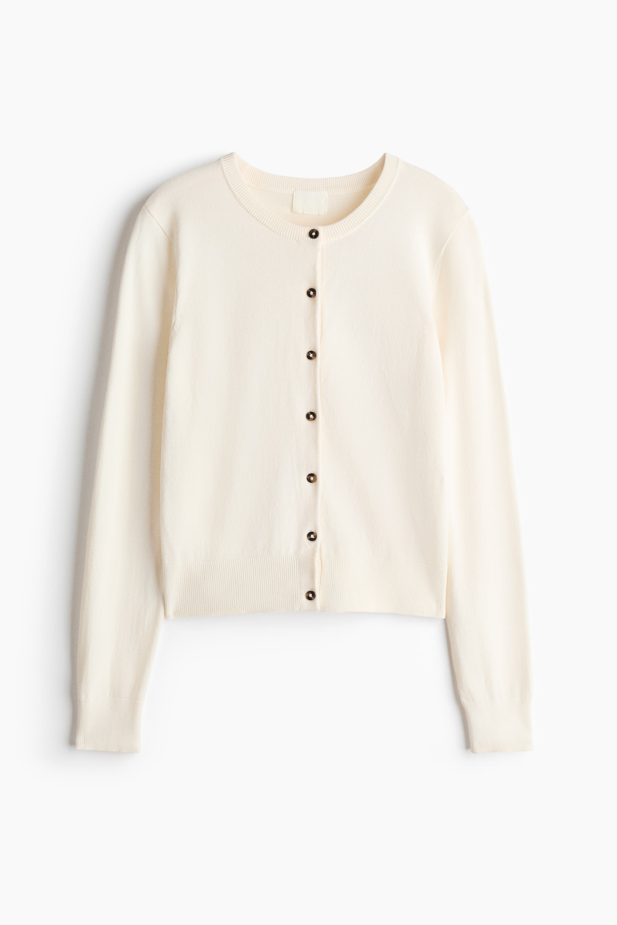 View larger image: The cream cardigan is displayed from the front, showcasing a soft, fine-knit texture. Dark buttons run down the center front, while ribbing details the round neckline, cuffs, and hem.