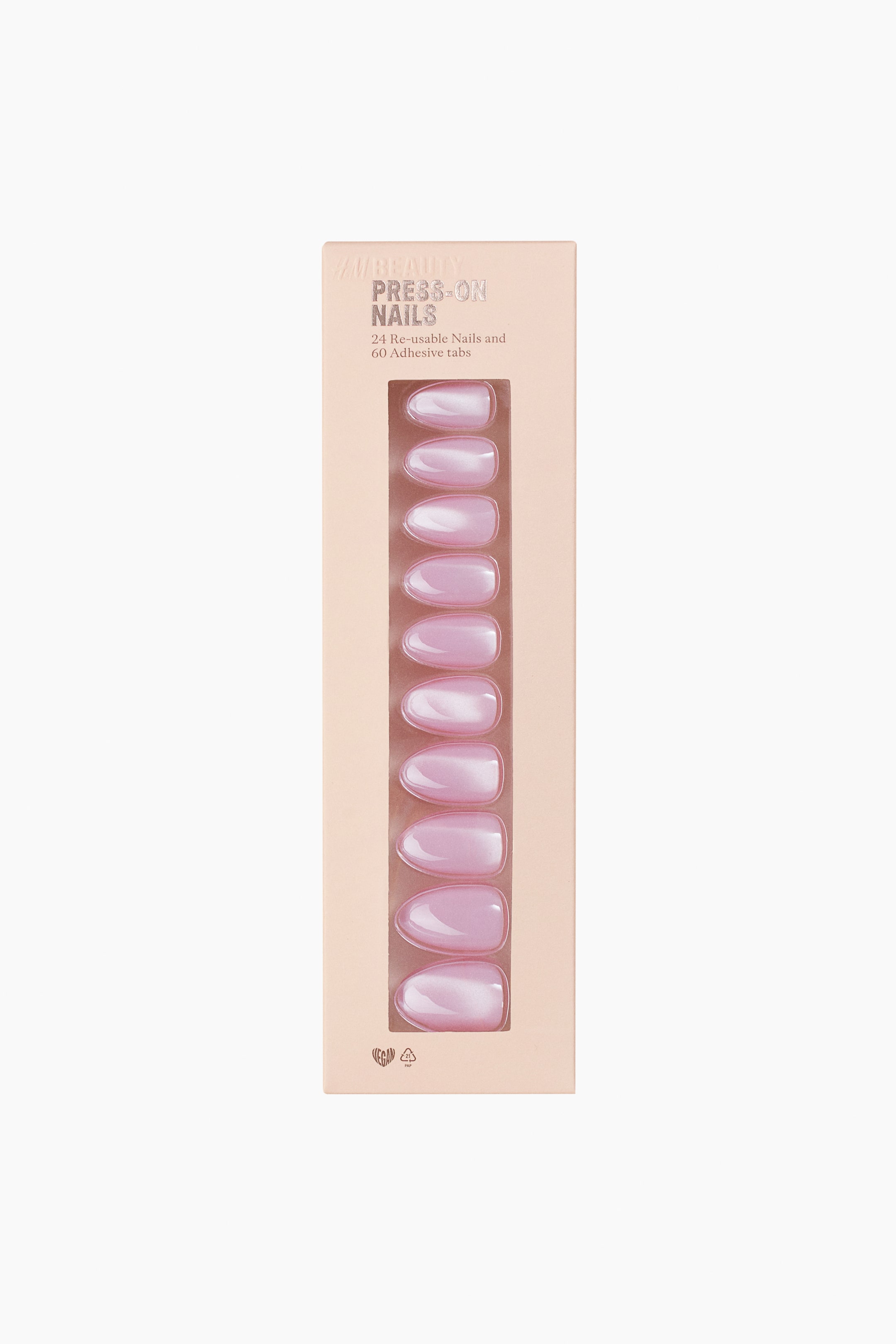 View larger image: A rectangular light peach box of H&M Beauty Press-On Nails is shown from the front, featuring a vertical clear window displaying ten light pink, oval-shaped nails with a pearlescent finish. Text on the box indicates "24 Re-usable Nails and 60 Adhesive tabs."