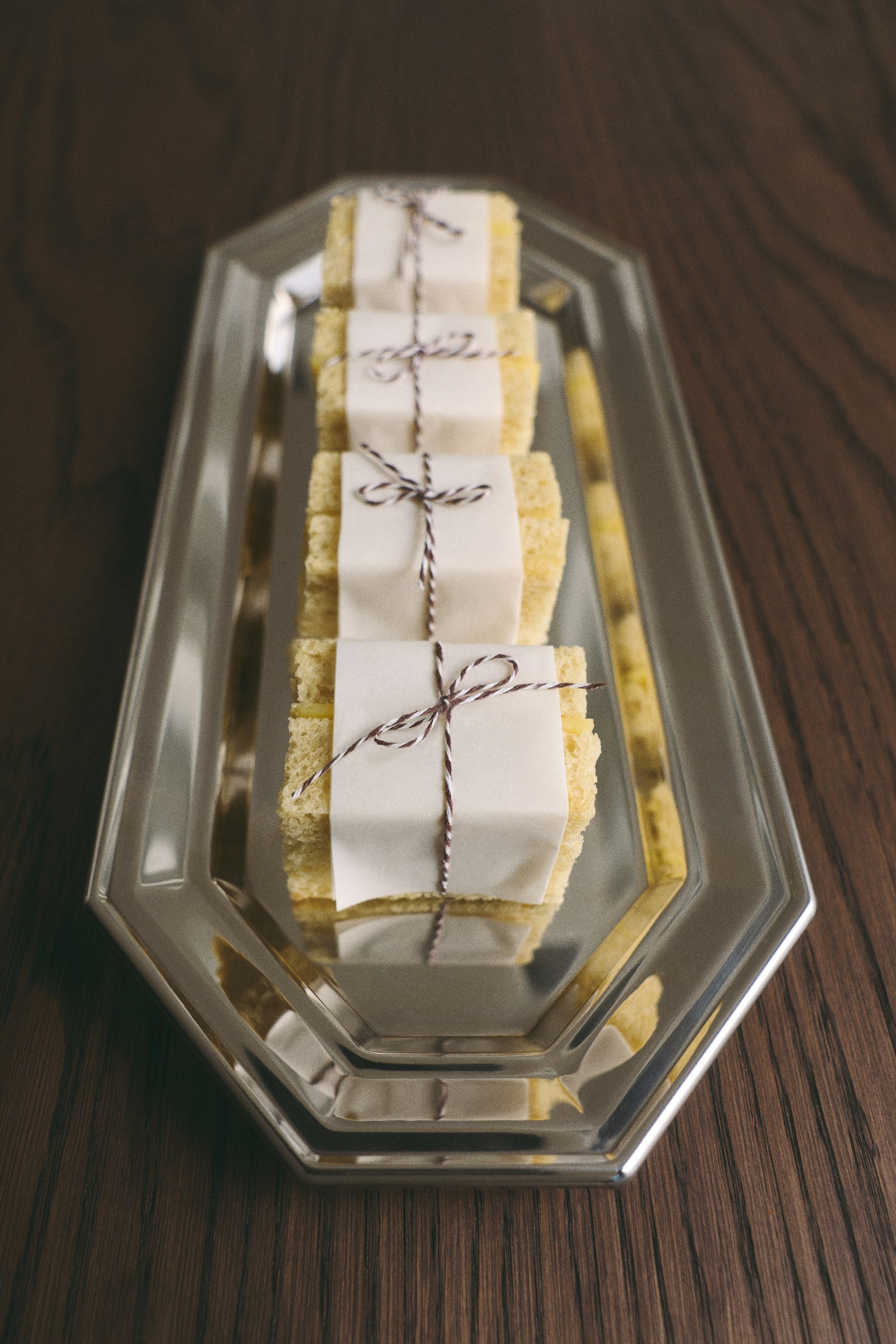 An elongated octagonal tray is facing front, showcasing a highly polished, silver-toned metallic finish with a reflective, mirror-like surface. The tray features a flat, recessed centre surrounded by a tiered, raised rim with clean, angled edges. - 1