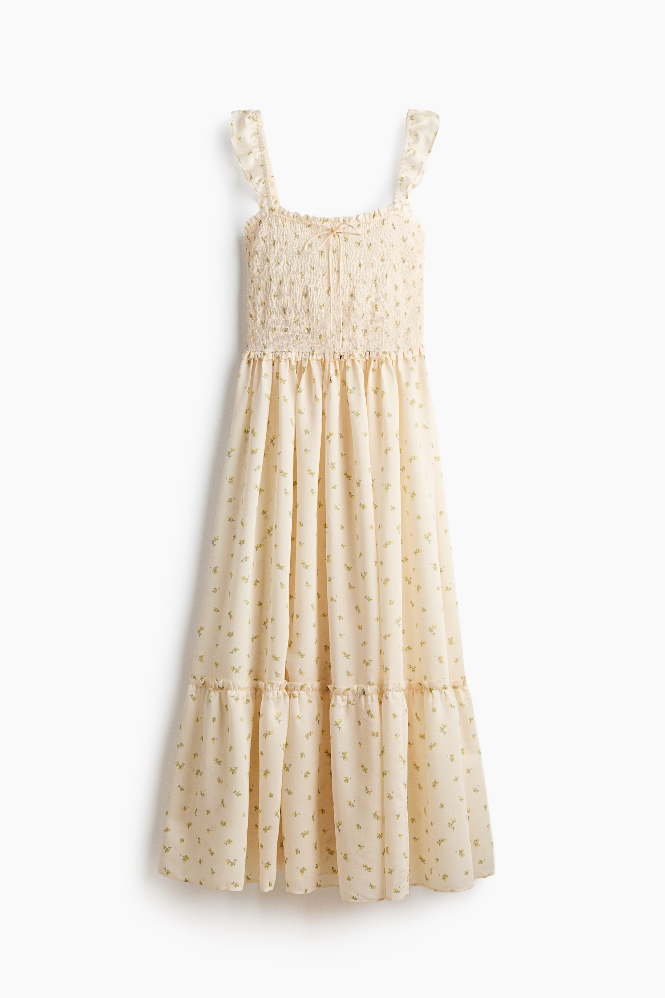 Größeres Bild anzeigen: Ein wadenlanges Kleid präsentiert sich von vorne und besteht aus einem cremefarbenen Stoff mit einem kleinen grünen und gelben Blumenmuster. Es ist mit elastischen, mit Rüschen besetzten Schulterträgern, einem gesmokten Oberteil mit einem zentralen Spaghettizugband, einer gerafften Taillennaht und einem ausgestellten Rock mit einer gerafften, mit Rüschen besetzten Stufe über dem Saum gestaltet.