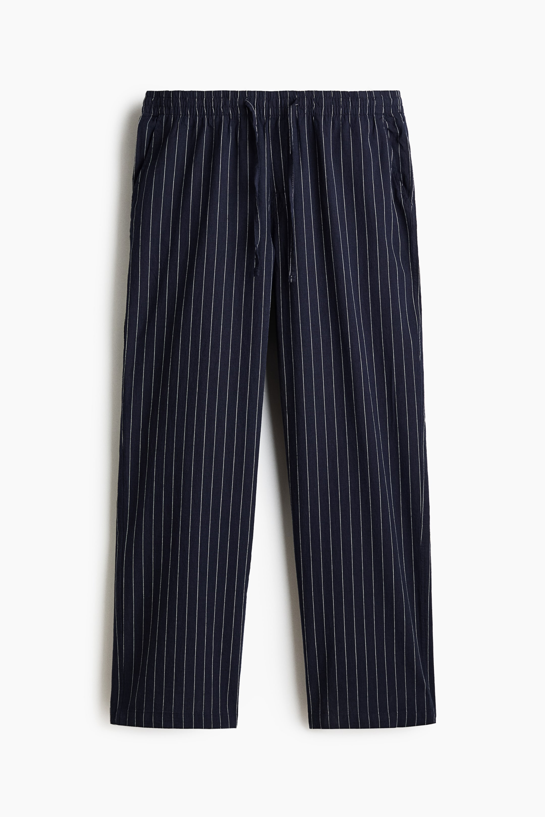 View larger image: The navy blue pinstripe trousers feature an elasticated waistband with a visible drawstring and side pockets, offering a straight-leg fit from the front.