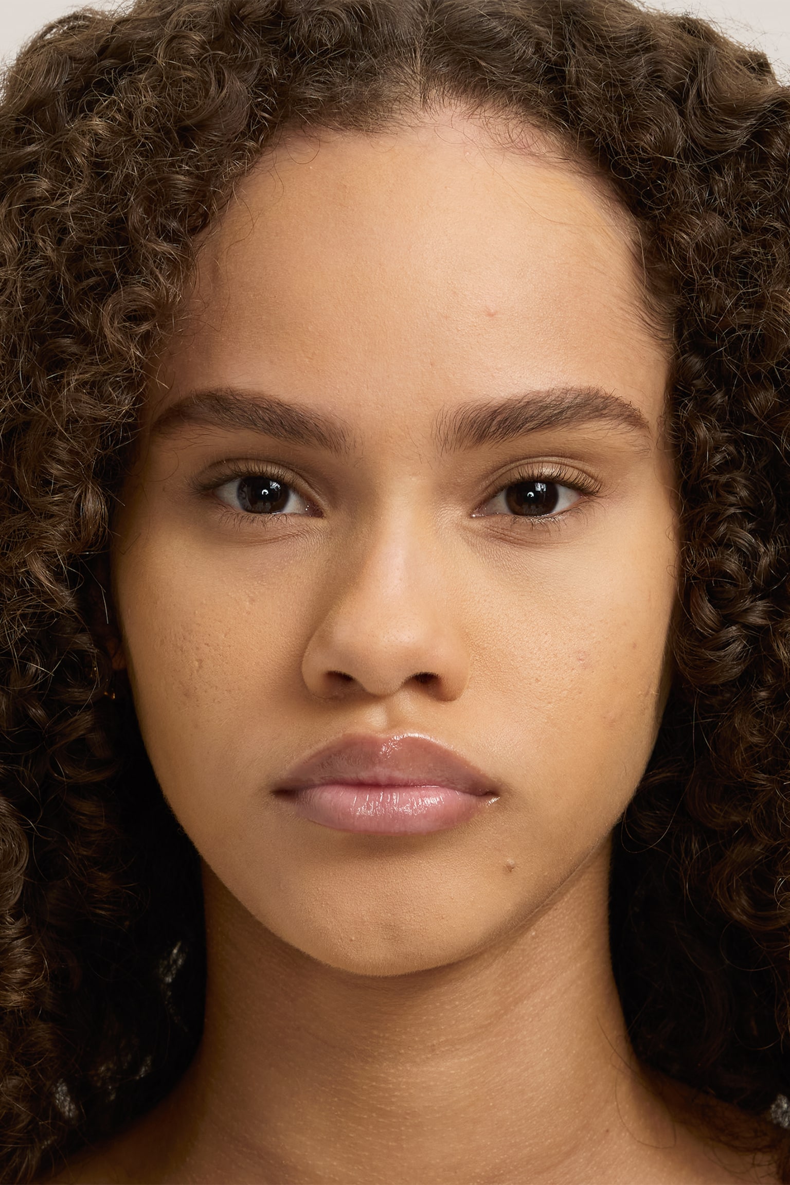 Natural Blur Powder Foundation syns pÃ¥ en modells ansikte frÃ¥n en framifrÃ¥n-vinkel och visar en jÃ¤mn, matt och enhetlig finish. Produkten mjukar tydligt upp hudens ÑÐµÐºÑÑur och skapar ett suddigt, naturligt utseende. - 1