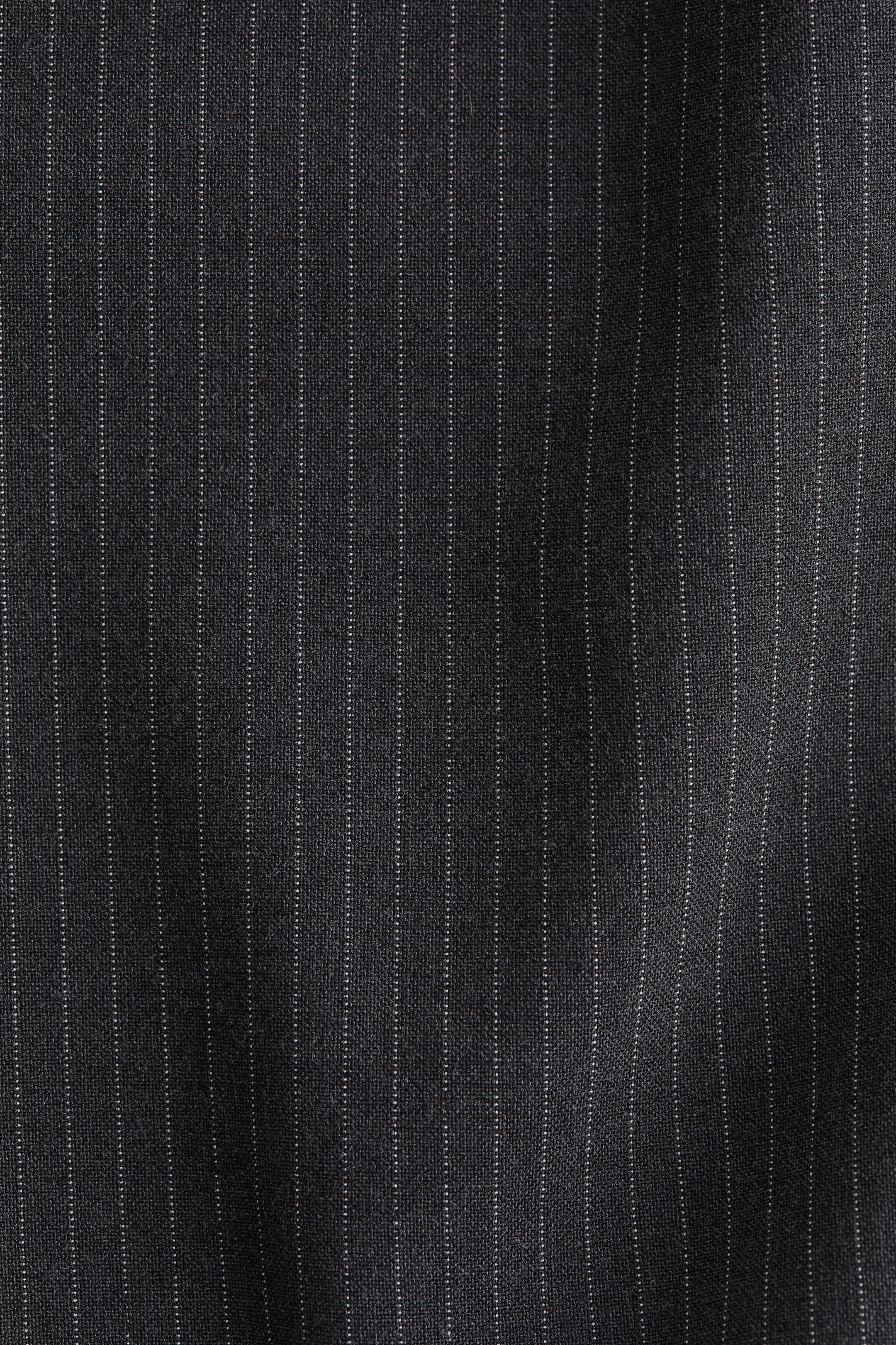 Ver imagen más grande: Una tela tejida muestra un color carbón oscuro con finas rayas verticales blancas.