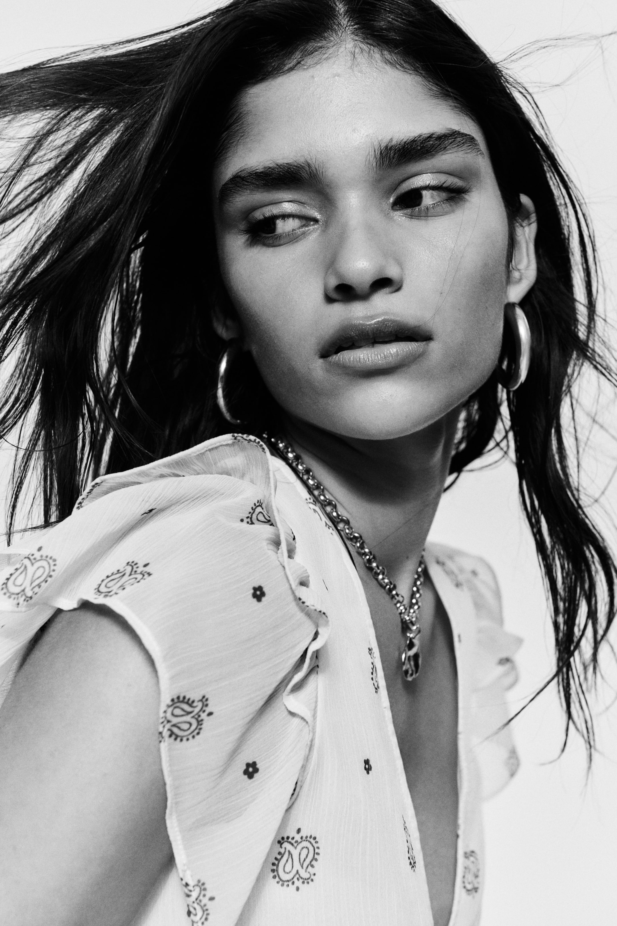 View larger image: A crinkled chiffon top, featuring a deep V-neckline and short flutter sleeves with frill trims over the shoulders, is being worn by the model. 