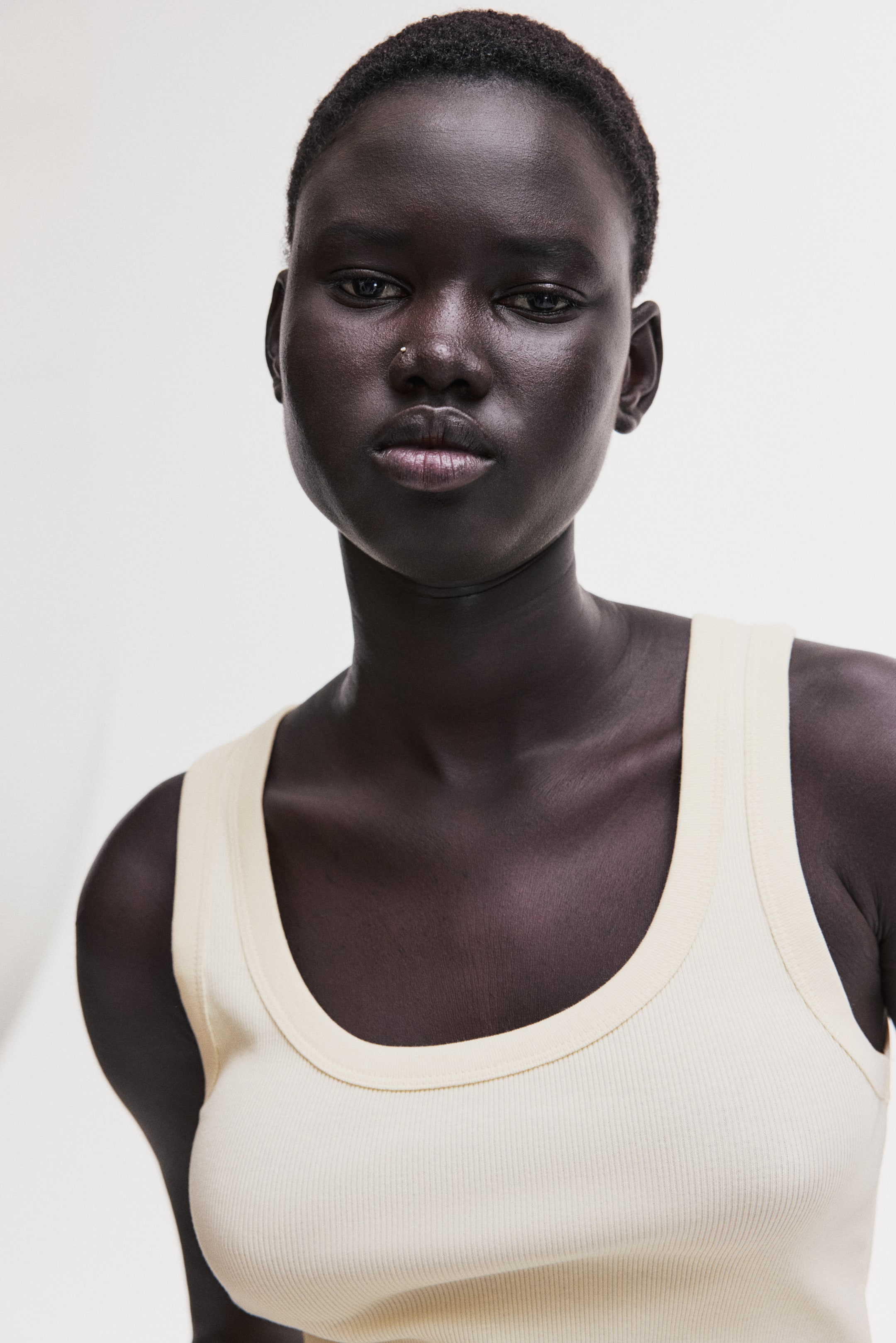 View larger image: A pale yellow ribbed-knit tank top features a scooped neckline and wide straps with binding along the edges, fitting close to the body.