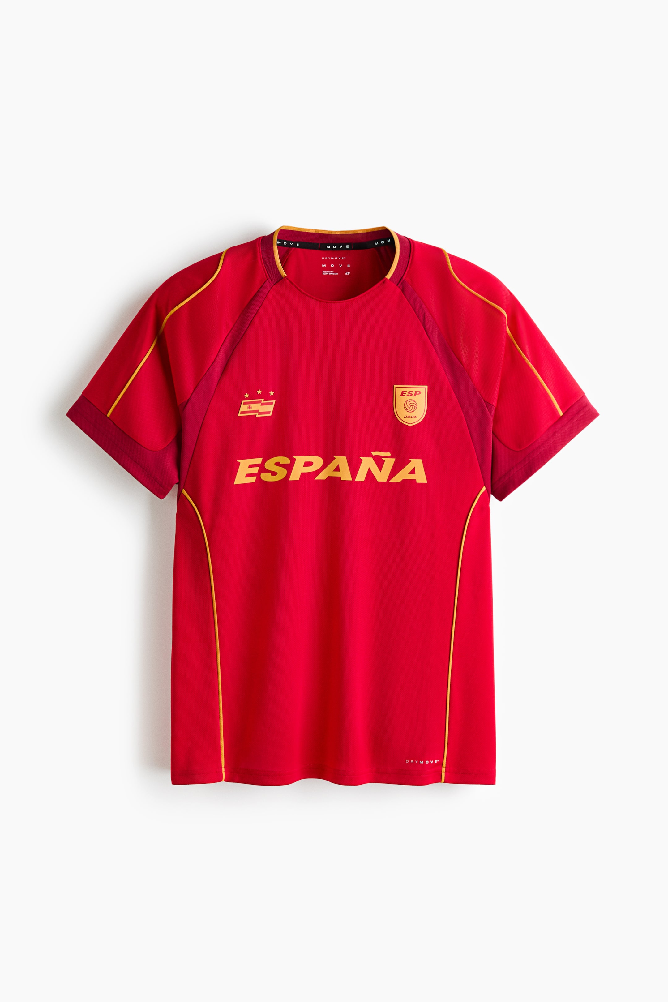 View larger image: A red short-sleeved jersey is shown from the front, featuring a round neckline with yellow and red trim, and yellow piping running along the raglan sleeve seams and down the sides. The word "ESPAÑA" appears in large yellow letters across the chest, accompanied by a yellow flag-like emblem with three stars on the left and a yellow emblem with "ESP 2024" on the right. The short sleeves have ribbed cuffs.