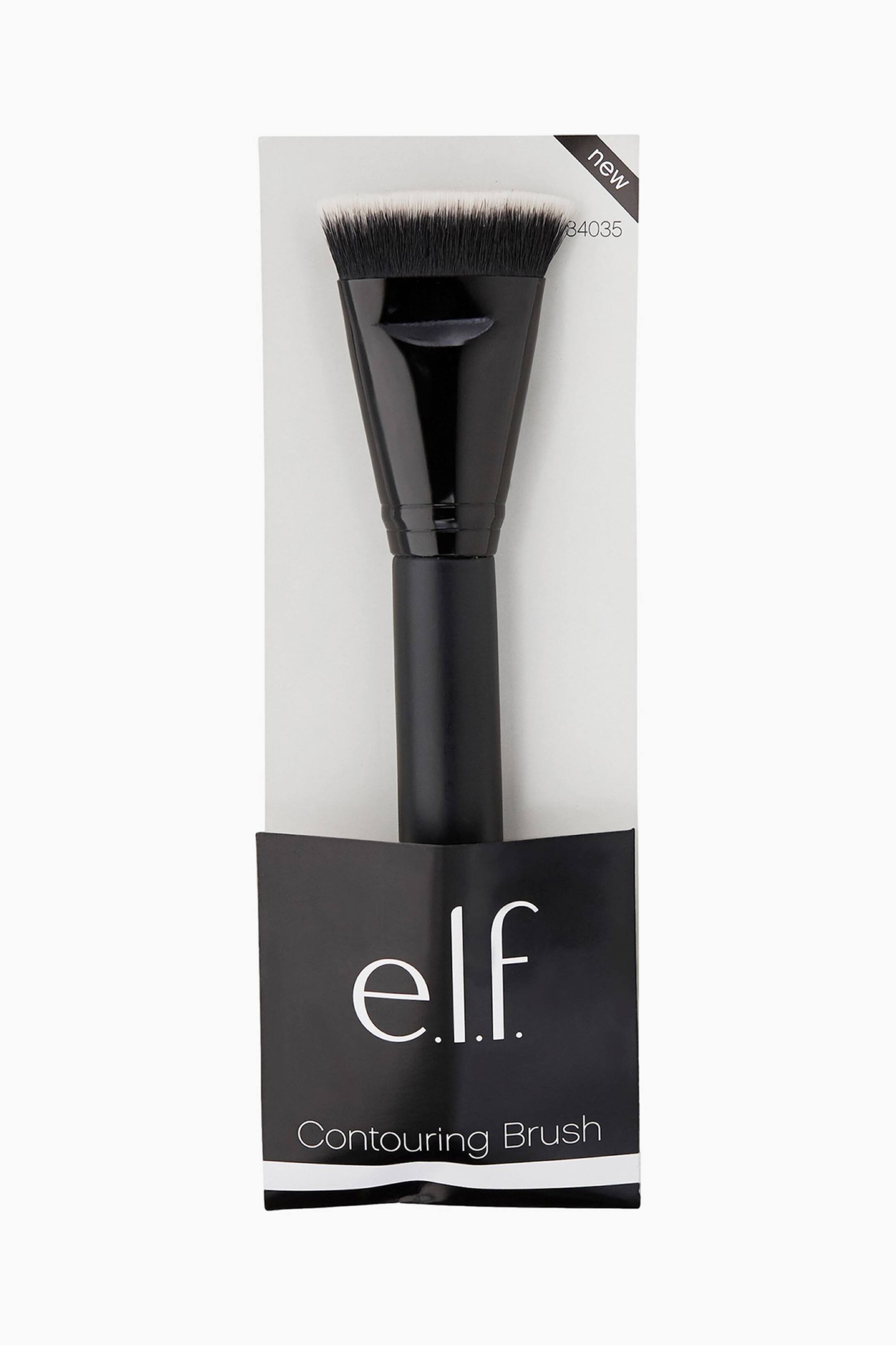 Vis større bilde: En elf Contouring Brush vises forovervendt i sin svart-hvite detaljhandel emballasje. Børsten har et matt svart håndtak, en blank, avsmalnende svart hylse, og tettpakkede, to-tonede svarte og hvite børstehår som danner en flat, lett vinklet topp. Emballasjen viser "elf"-logoen, teksten "Contouring Brush", og en "ny" etikett.