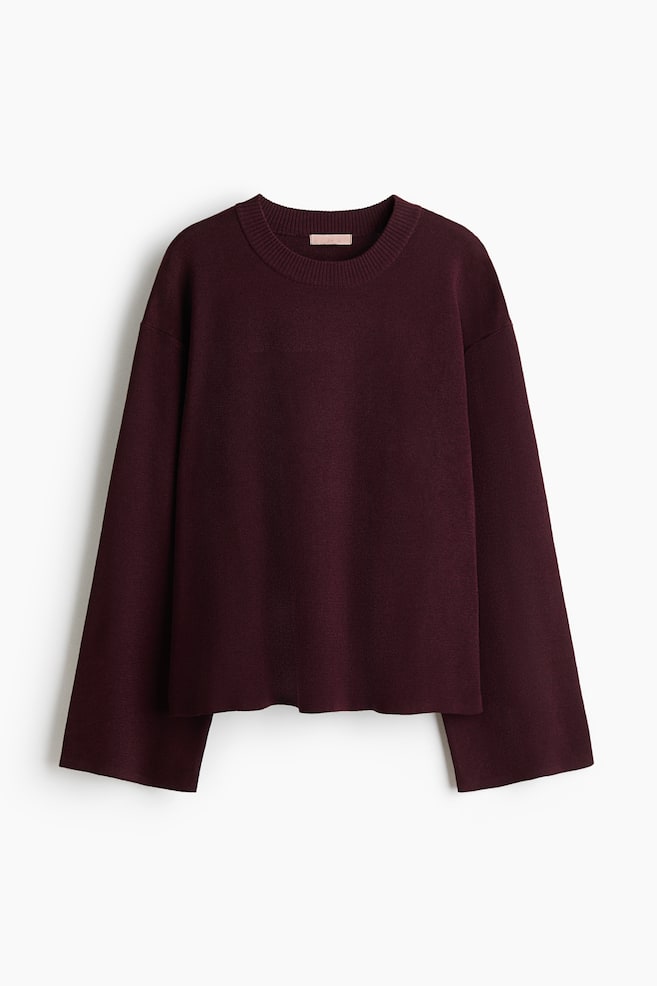 A maroon oversized jumper is shown front-on. It features a fine knit with a ribbed crew neck and long, gently flared sleeves. - 1