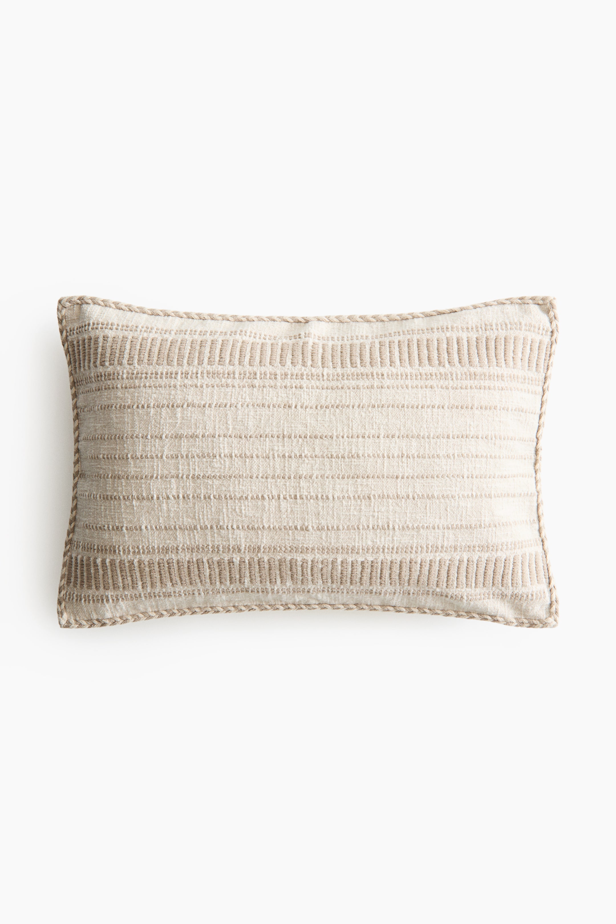 View larger image: A rectangular cushion cover showcases its front, crafted from a rustic cream-coloured cotton weave. It features horizontal textured patterns in tan across the front and is finished with a braided trim along all edges.