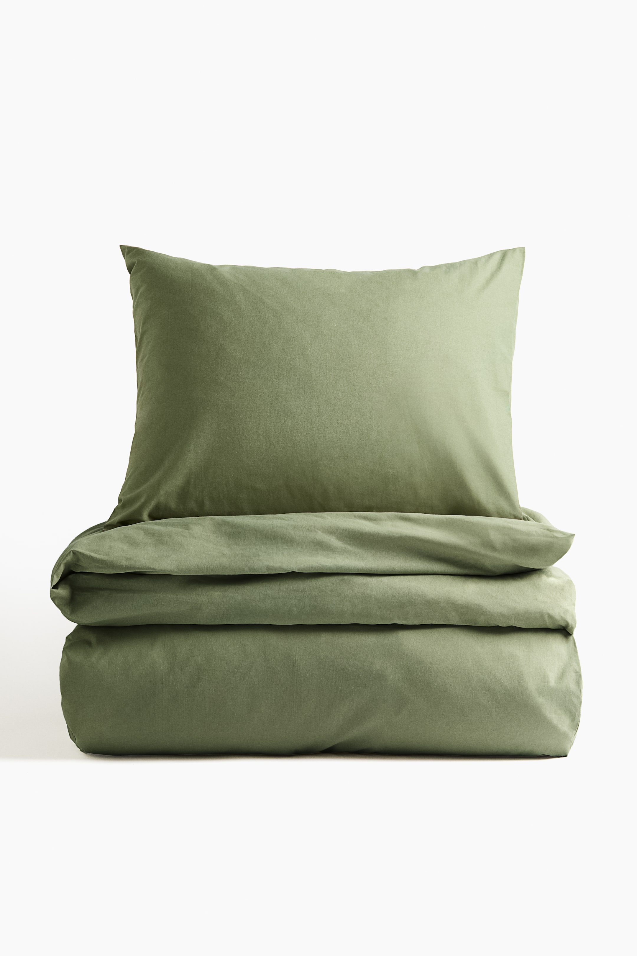 View larger image: A single duvet cover set is displaying a muted green color. It is featuring a fine-threaded cotton fabric, with a neatly folded duvet cover and one pillowcase lying flat on top.