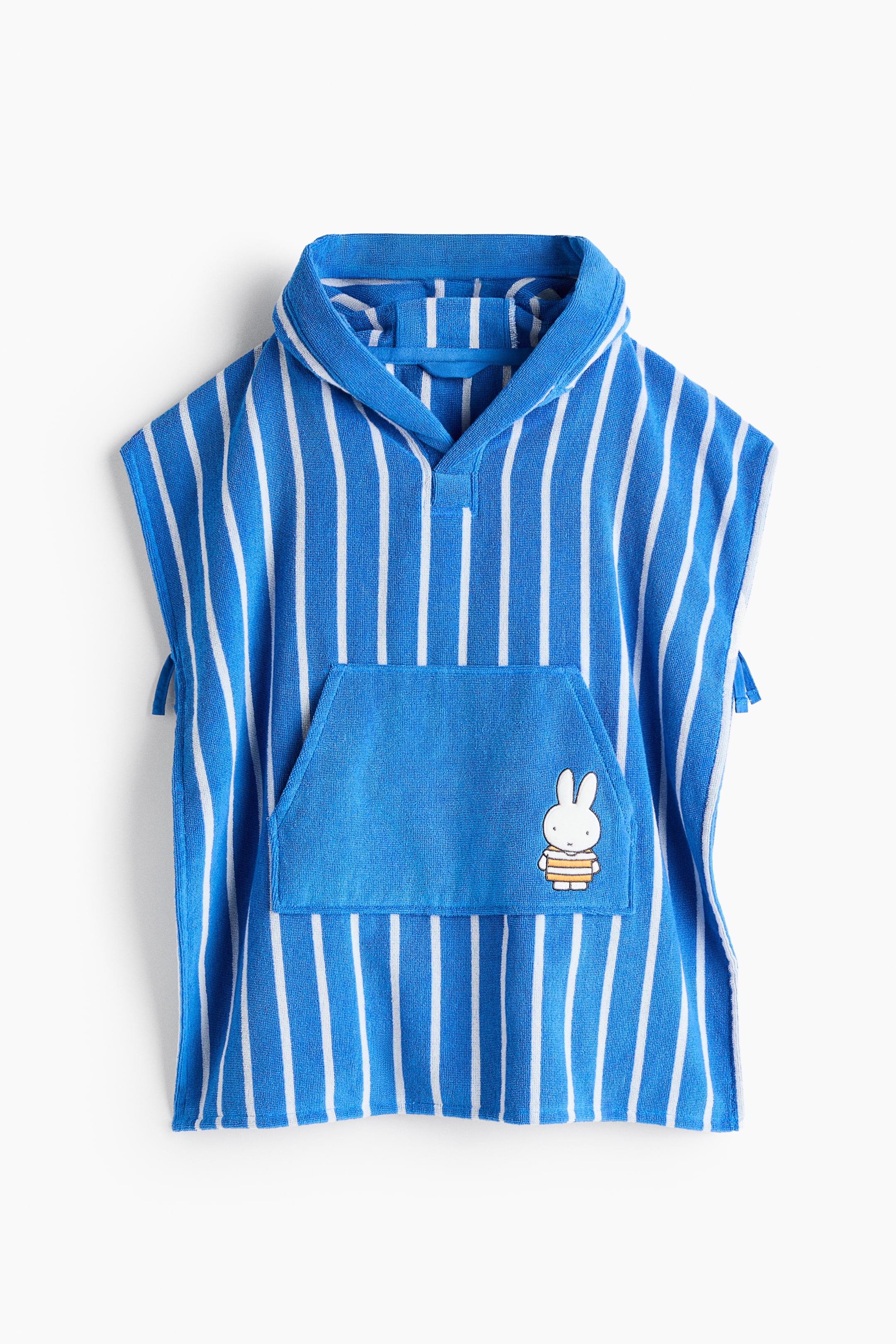 Grösseres Bild ansehen: Ein Kinder-Kapuzenhandtuch-Poncho zeigt seine Vorderseite mit blauen und weißen vertikalen Streifen. Es ist mit einer Kapuze, einem V-Ausschnitt und einer großen blauen Kängurutasche auf der Vorderseite gestaltet, die mit einem Miffy-Charakter-Patch versehen ist.