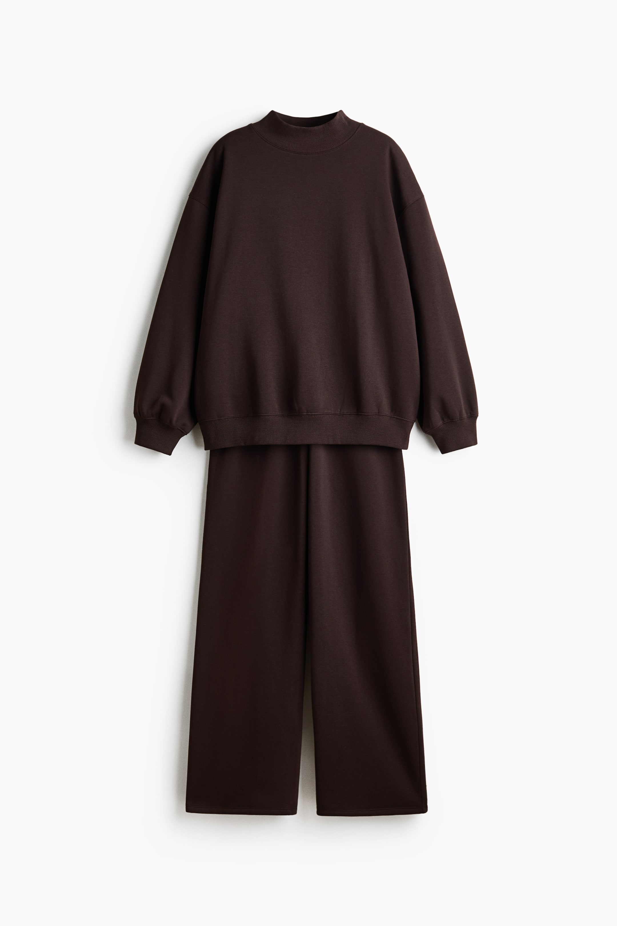 Grotere afbeelding bekijken: Een donkerbruin tweedelig setje met een sweatshirt in relaxed fit, een opstaande kraag, lange mouwen en geribde boorden en zoom, gecombineerd met een bijpassende broek met wijde pijpen.