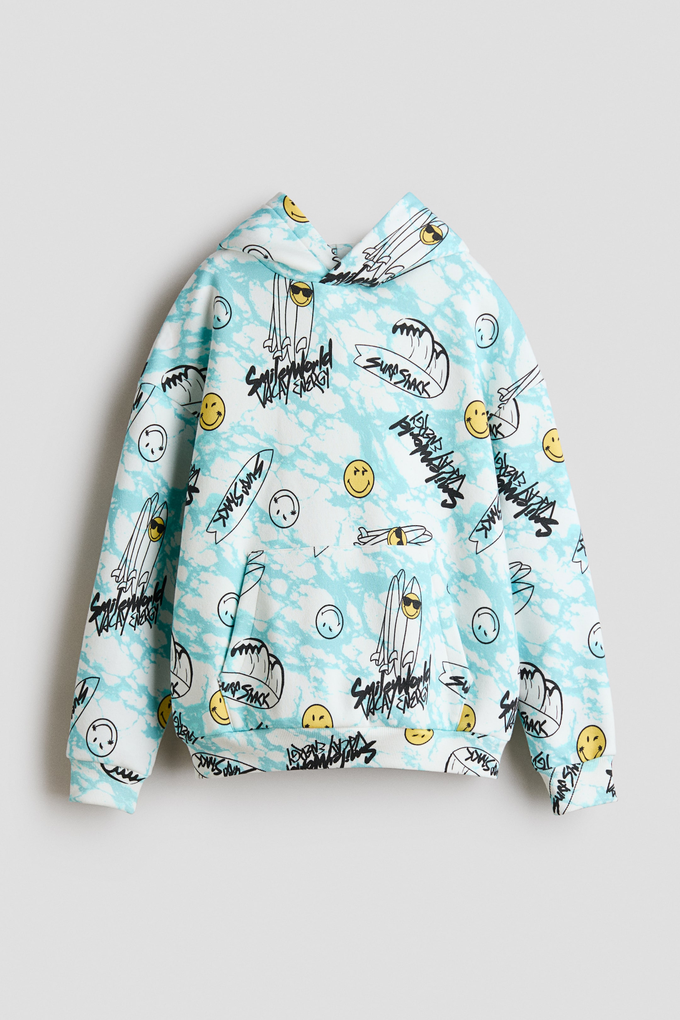 Se større billede: En hættetrøje vender fronten fremad, med et lyseblåt og hvidt marmoreret mønster med sorte og gule grafik af surfbrætter, bølger, smiley-ansigter og tekst som "Surf Shack" og "Smile World Vacay Energy." Den er designet med en hætte, lange ærmer med ribbede manchetter, en ribbet kant og en front kængurulomme.