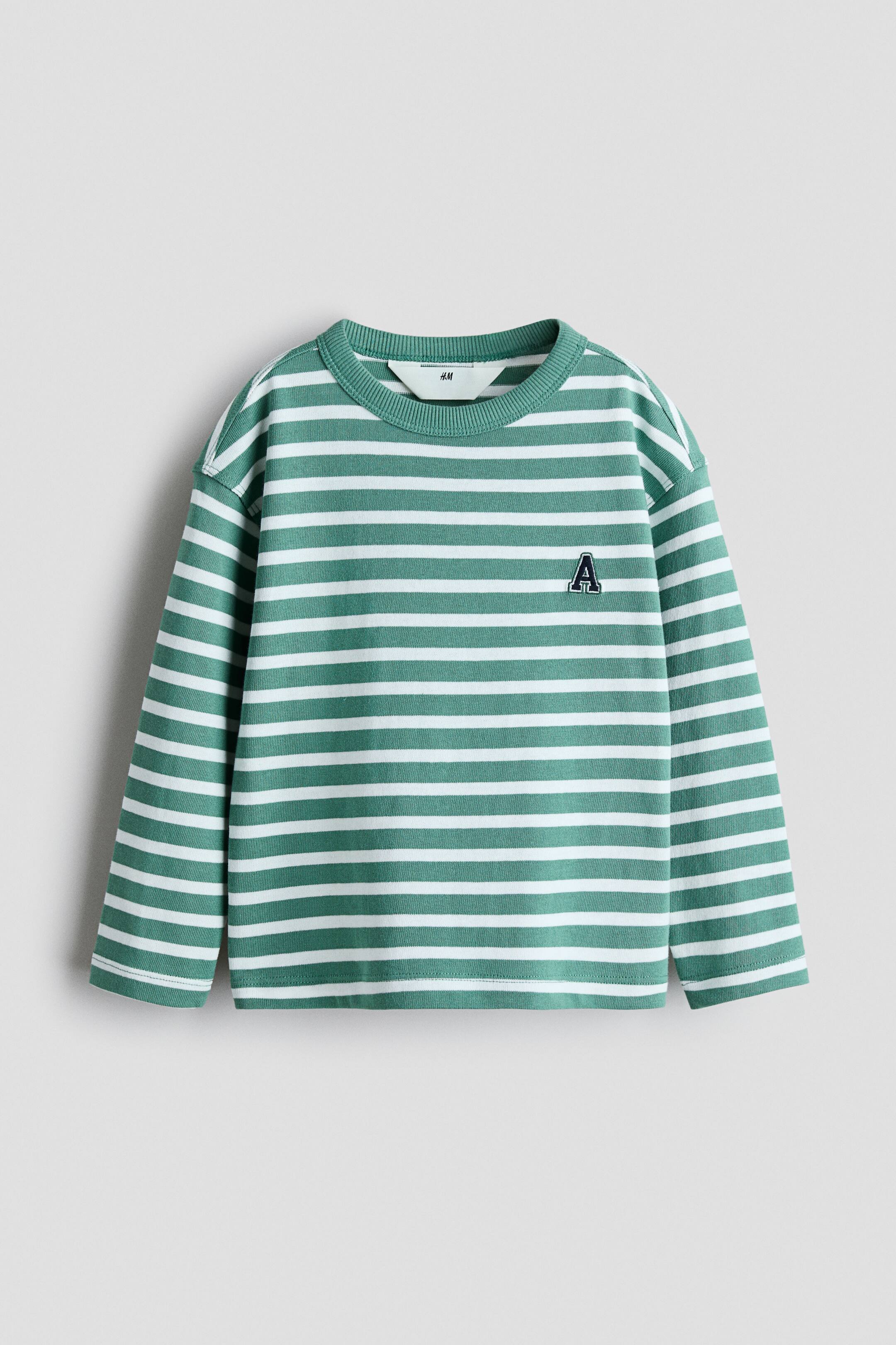 View larger image: A long-sleeve shirt showcases horizontal green and white stripes, featuring a ribbed crew neck and an embroidered dark letter A on the left chest. A white H&M tag is visible at the back of the neck.