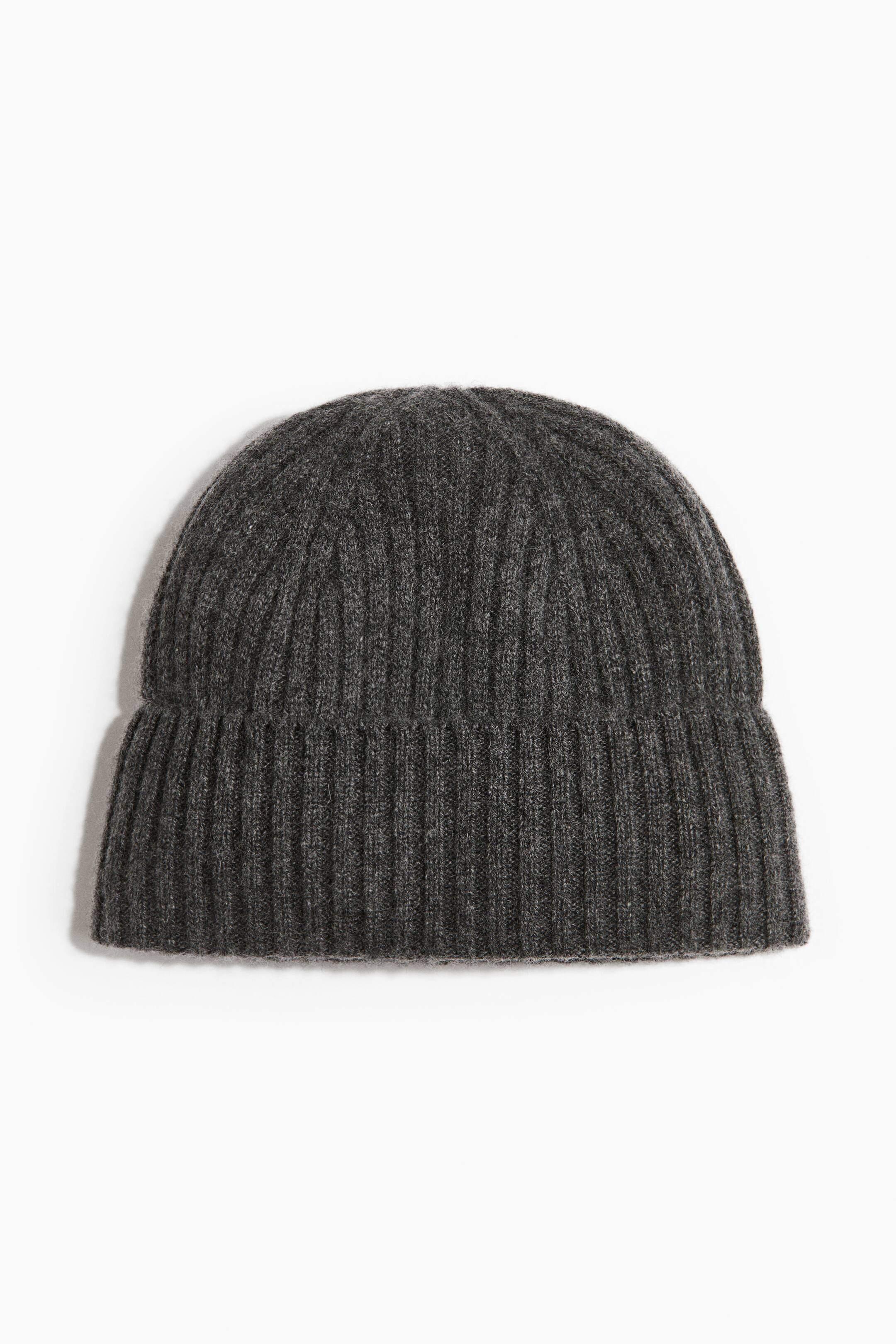 View larger image: A dark grey rib-knit cashmere hat is shown from the front, featuring a wide turned-up cuff at the hem and a structured, dome-shaped design with vertical ribbing throughout.