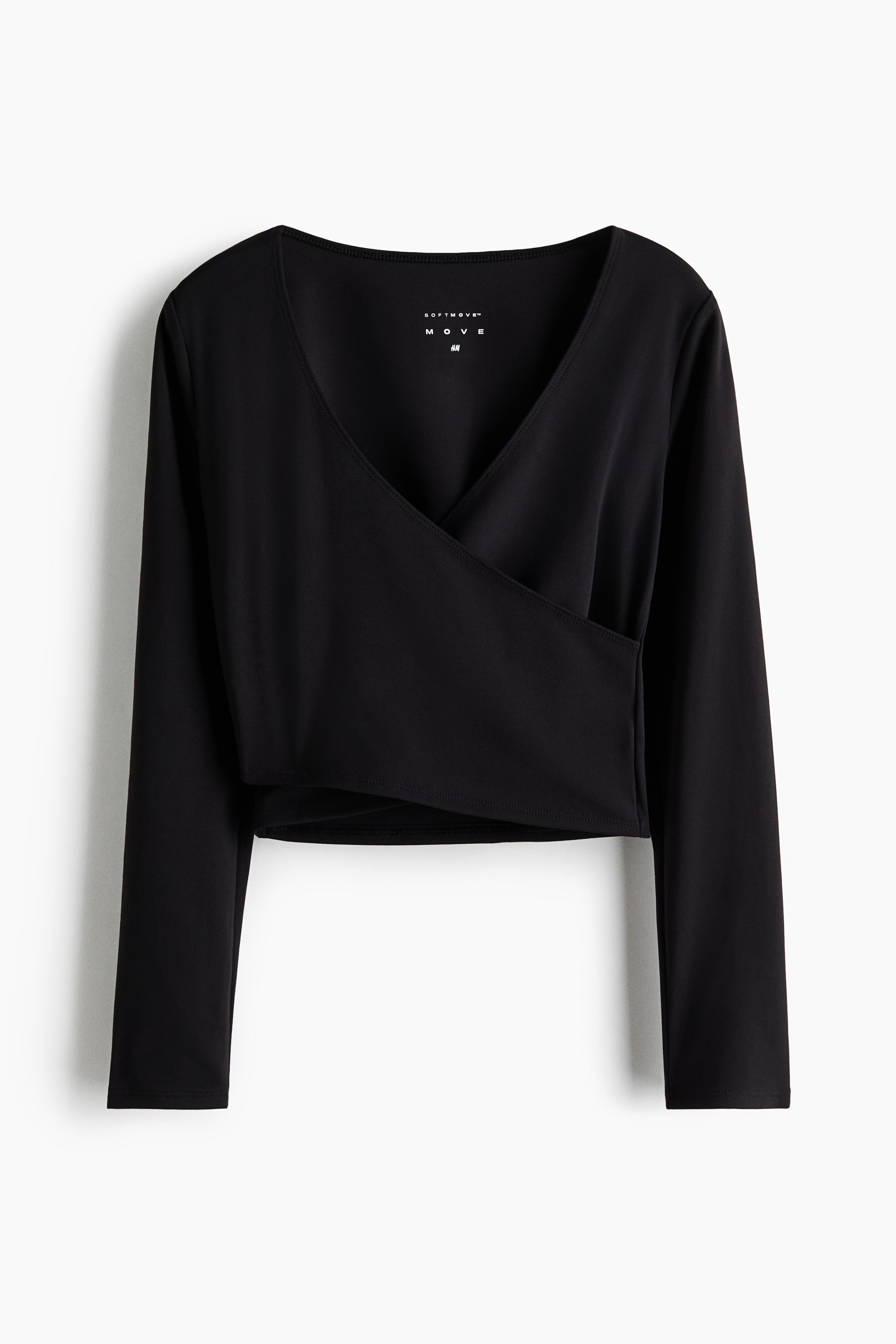A black, slim-fit long-sleeved activewear top is being worn from the front, featuring a deep V-shaped neckline and a sewn-in wrap-front design. The top is paired with matching black cropped activewear trousers.