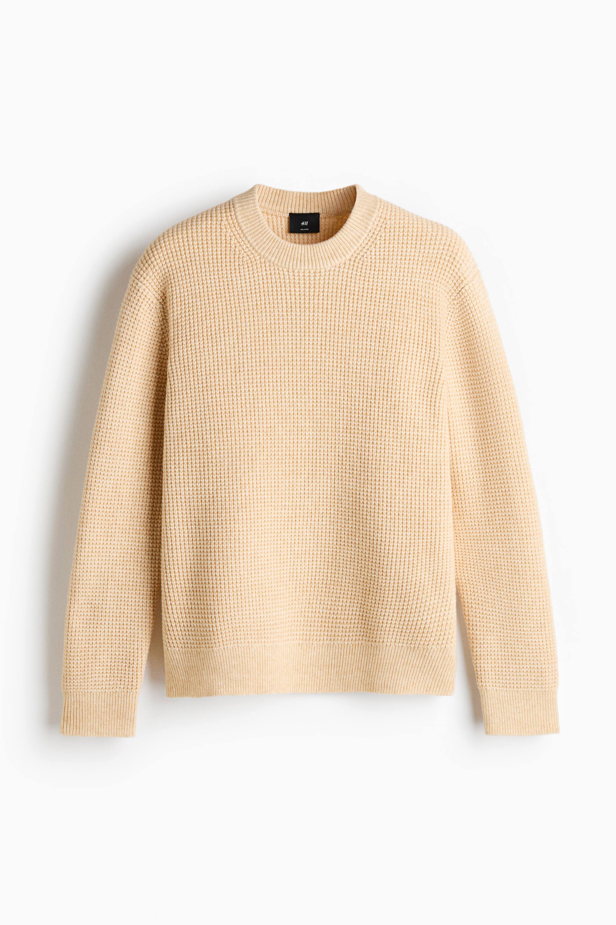 View larger image: A pale yellow sweater is shown from the front, featuring a prominent waffle knit texture. It is designed with a crew neck, ribbed cuffs, and a ribbed hem.