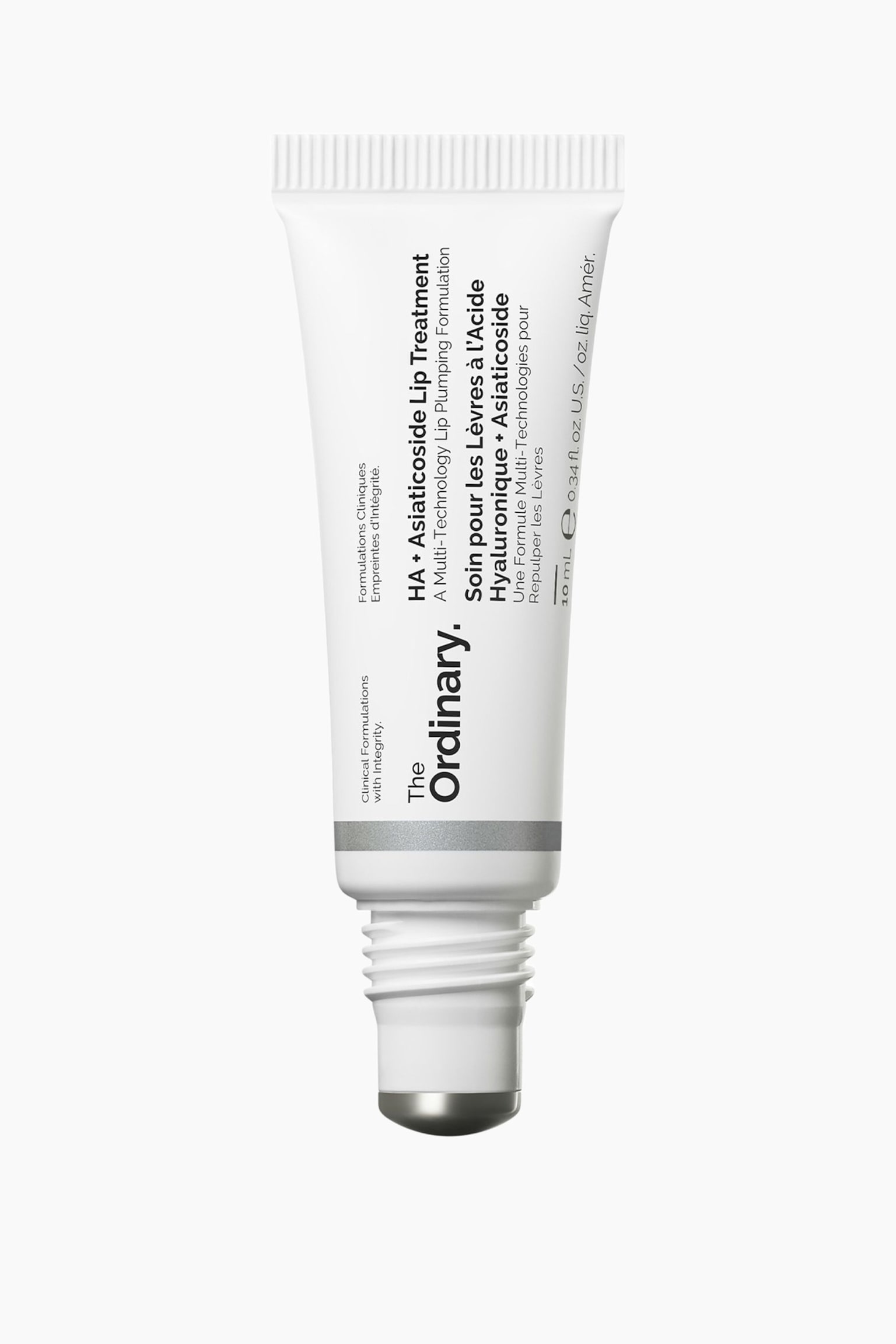 En vit klämtub med The Ordinary HA + Asiaticoside Lip Treatment visas upp och ner, med sin metalliska rollerball-applikator riktad nedåt. Tuben har svart varumärkes- och produkttext på framsidan, en tunn silverfärgad rand nära basen samt en räfflad, krusad kant upptill.