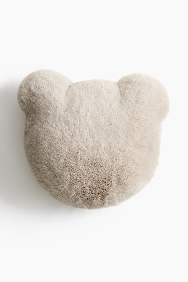 A bear-shaped cushion in a soft, fluffy light beige faux-fur fabric is facing forward, highlighting its plush texture. The cushion is featuring a rounded shape with two small, soft ears at the top. - 1