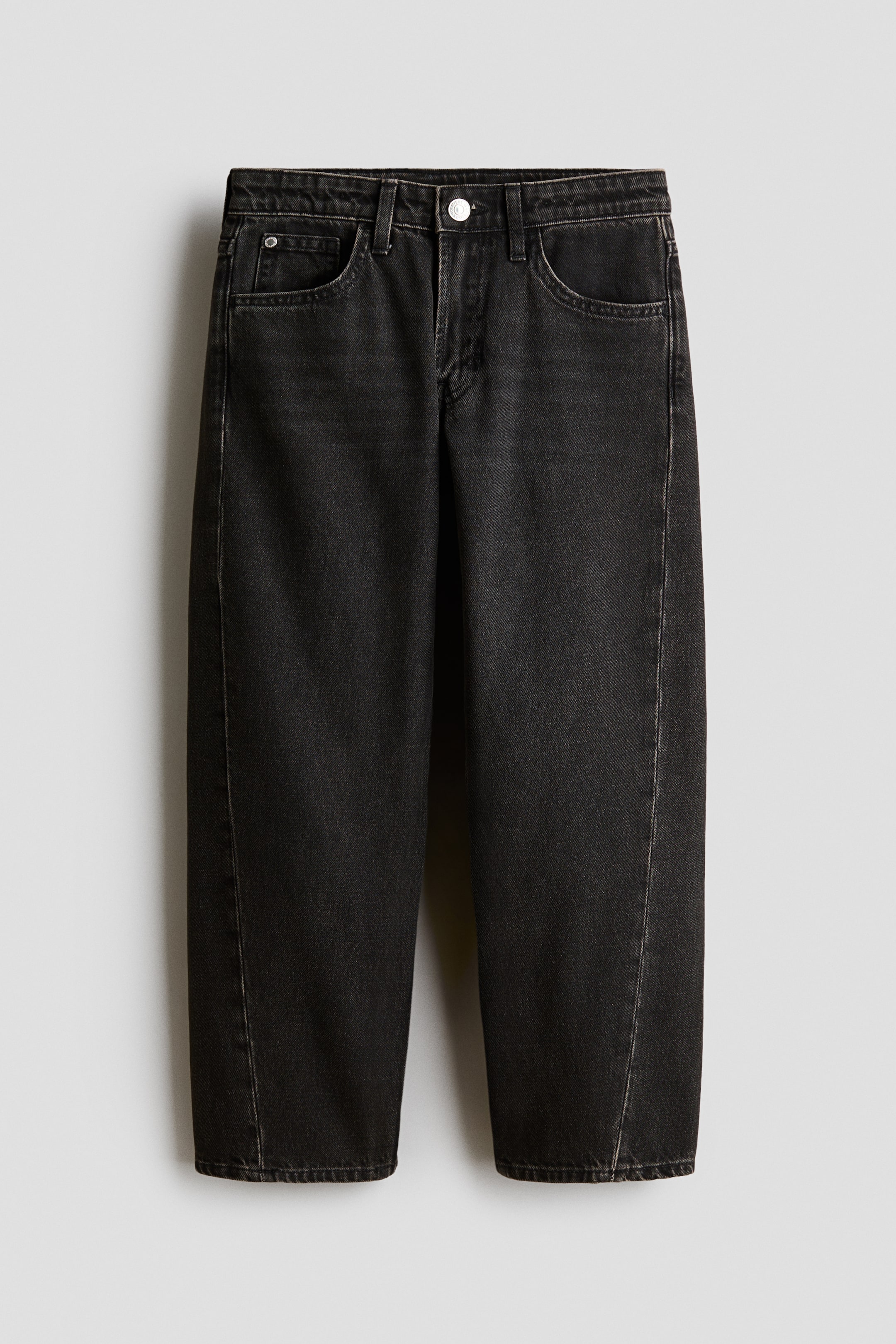 Vis større bilde: Et par vaskede svarte denimjeans er avbildet forfra, og viser en løs passform med rette ben og karakteristiske vridde sømmer som løper ned langs forsiden av hvert ben. Jeansene har en klassisk femlommers stil, beltehemper og lukking med metallknapp i livet.