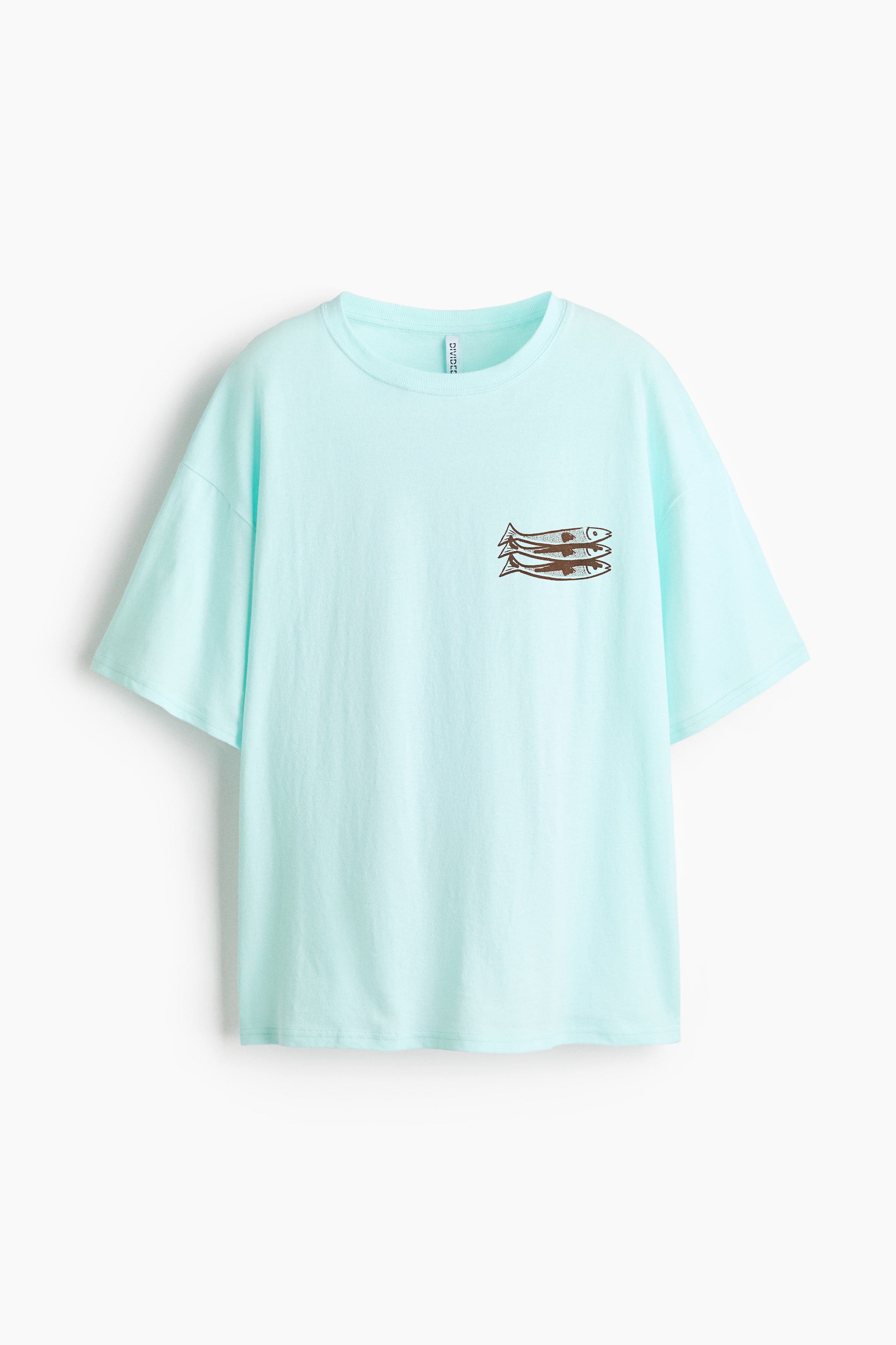 Ver imagen más grande: Una camiseta azul claro de talla grande se presenta en vista frontal, con un cuello redondo acanalado, hombros caídos y mangas cortas sueltas. Tres gráficos apilados de peces marrones detallan el área del pecho izquierdo.