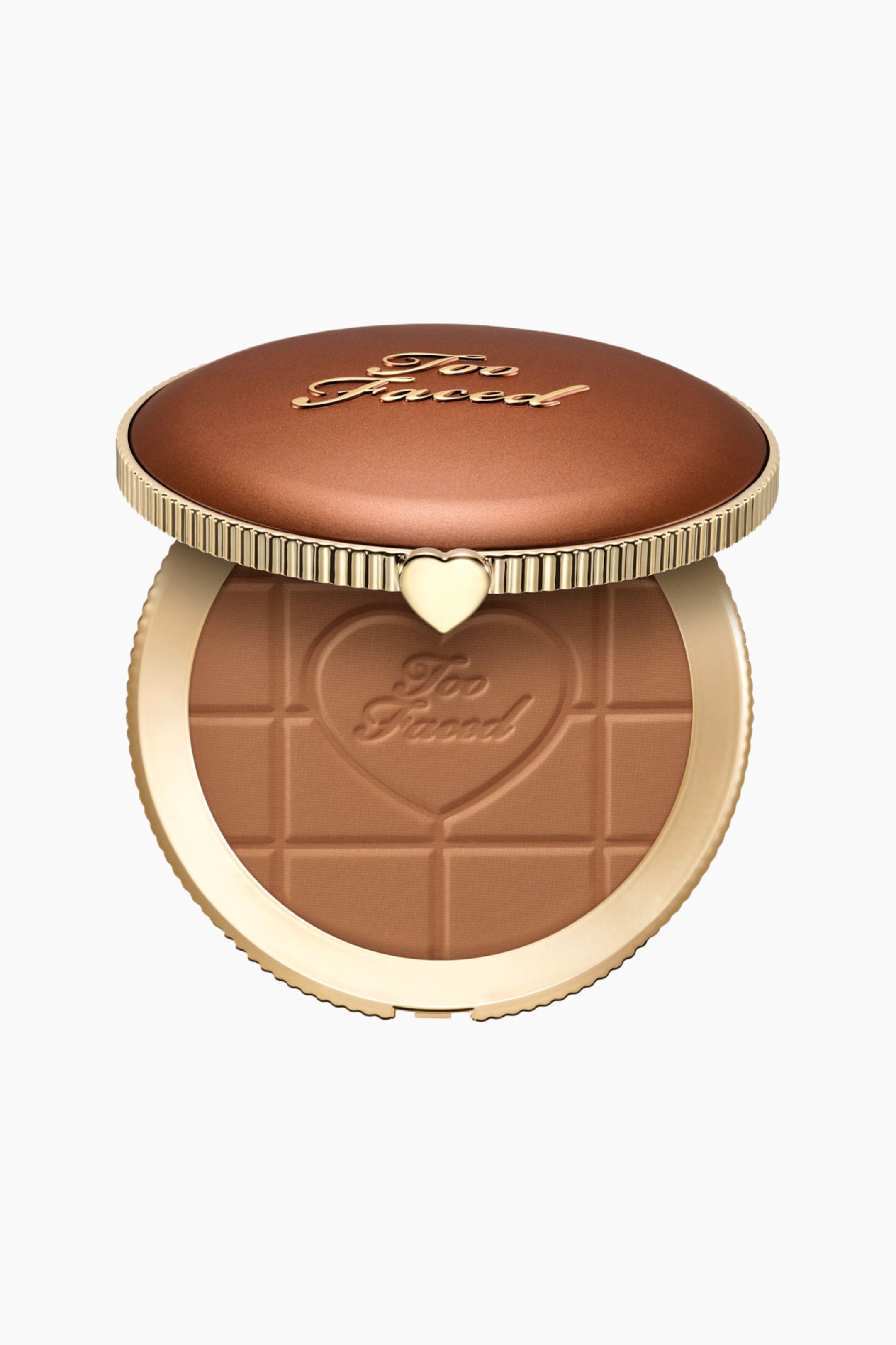Visa större bild: En Too Faced bronzerkompakt öppnas och är något vinklad mot betraktaren, vilket avslöjar dess varma bruna puder. Kompaktens bruna lock har "Too Faced" i guldfärgad skrift, en gyllene ribbad kant och ett litet guldfärgat hjärtlås som förbinder det med basen. Puderpannan är präglad med ett centralt hjärta innehållande texten "Too Faced", omgiven av ett rutmönster.