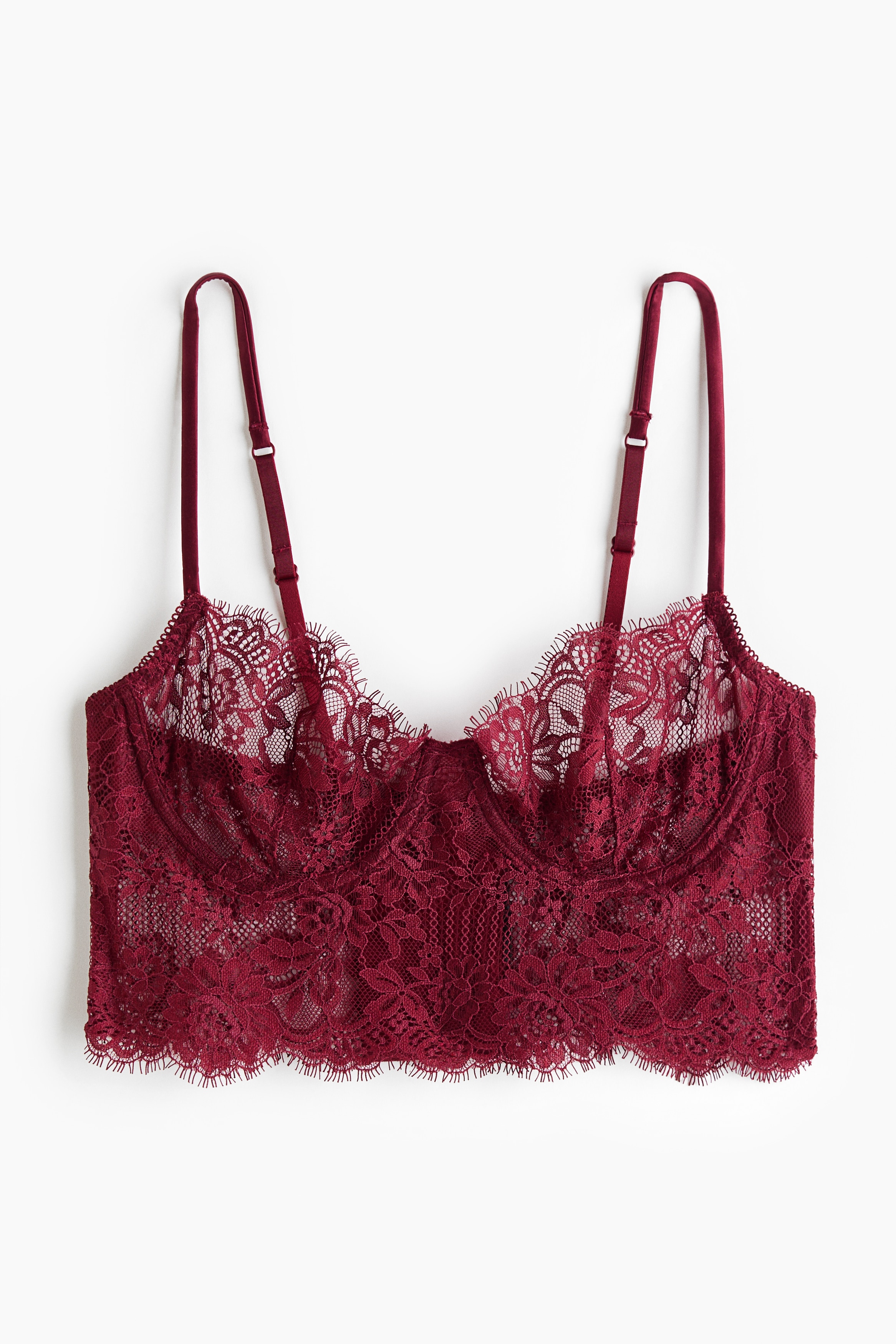 La modelo lleva un bralette de encaje rojo oscuro con copas con aros, borde festoneado y tirantes finos, combinado con una braguita de encaje a juego.